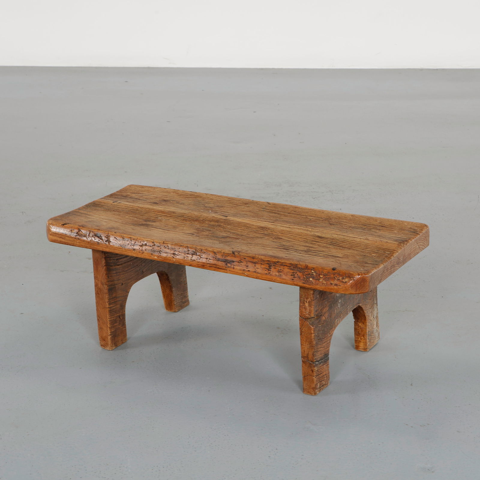 Brutalist Wood Coffee Table, 1950s: Executed in solid oak with a thick rectangular top displaying pronounced grain and natural irregularities. The sculptural arched supports emphasize the handcrafted construction and rustic character of