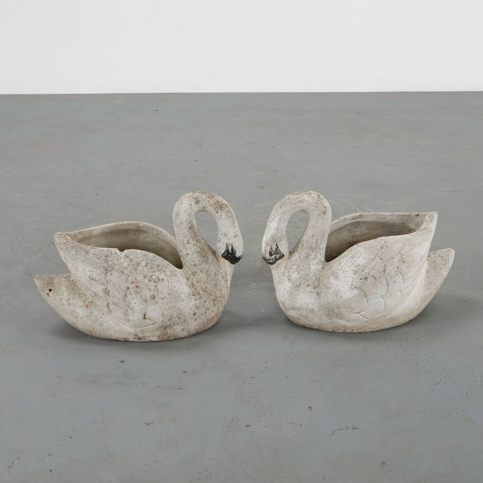 Pair of Swan Concrete Planters, 1960s: Cast in concrete and painted in white with subtle detailing, this pair of swan-shaped planters embodies playful romanticism. Their sculptural forms add both grace and nostalgia to outdoor compositions