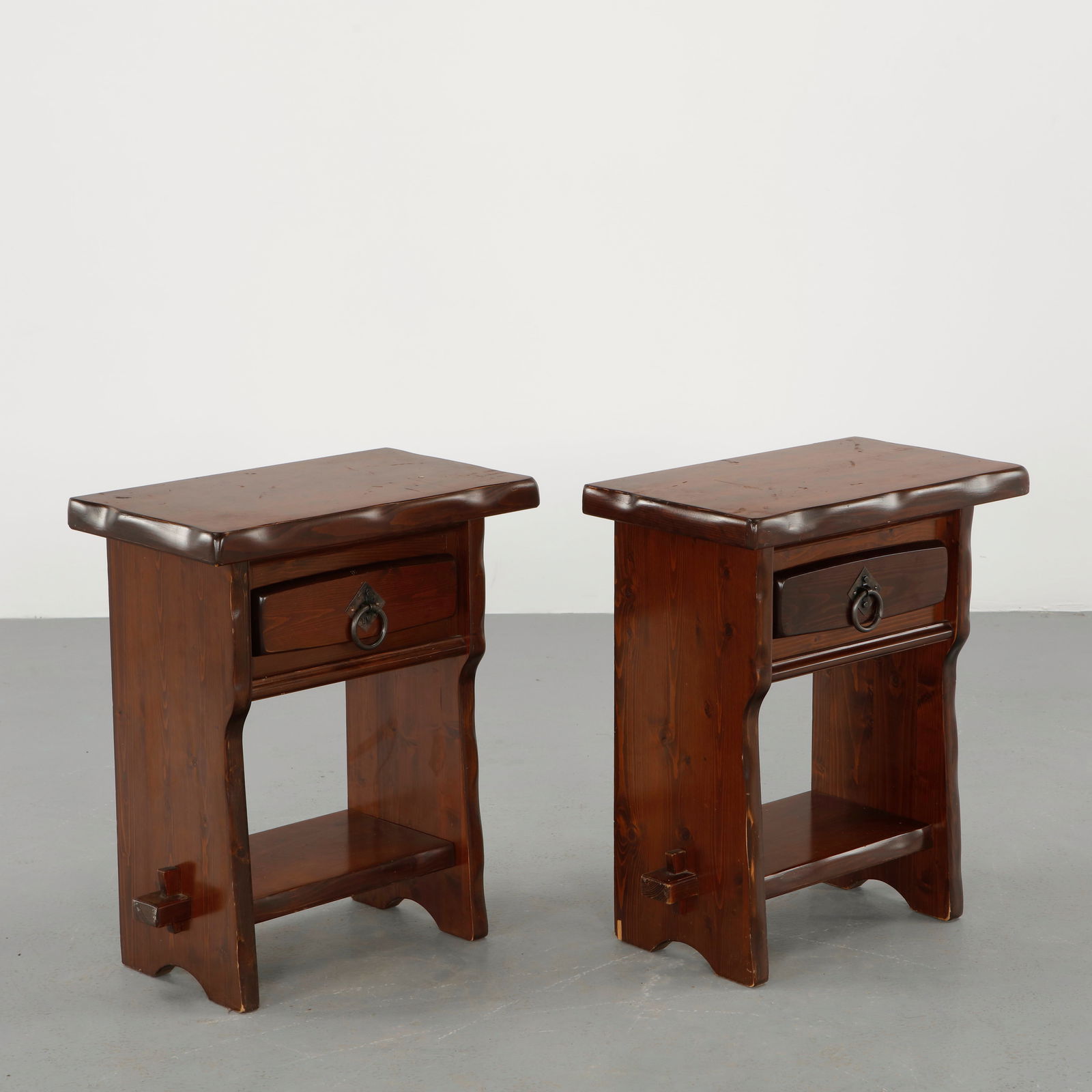 Olavi Hanninen, Pair of Brutalist Nightstand: Crafted in solid pine with sculpted edges, drawers fitted with iron ring pulls, and open lower shelves. The robust construction and warm stained finish reflect the rustic modernism associated with Han