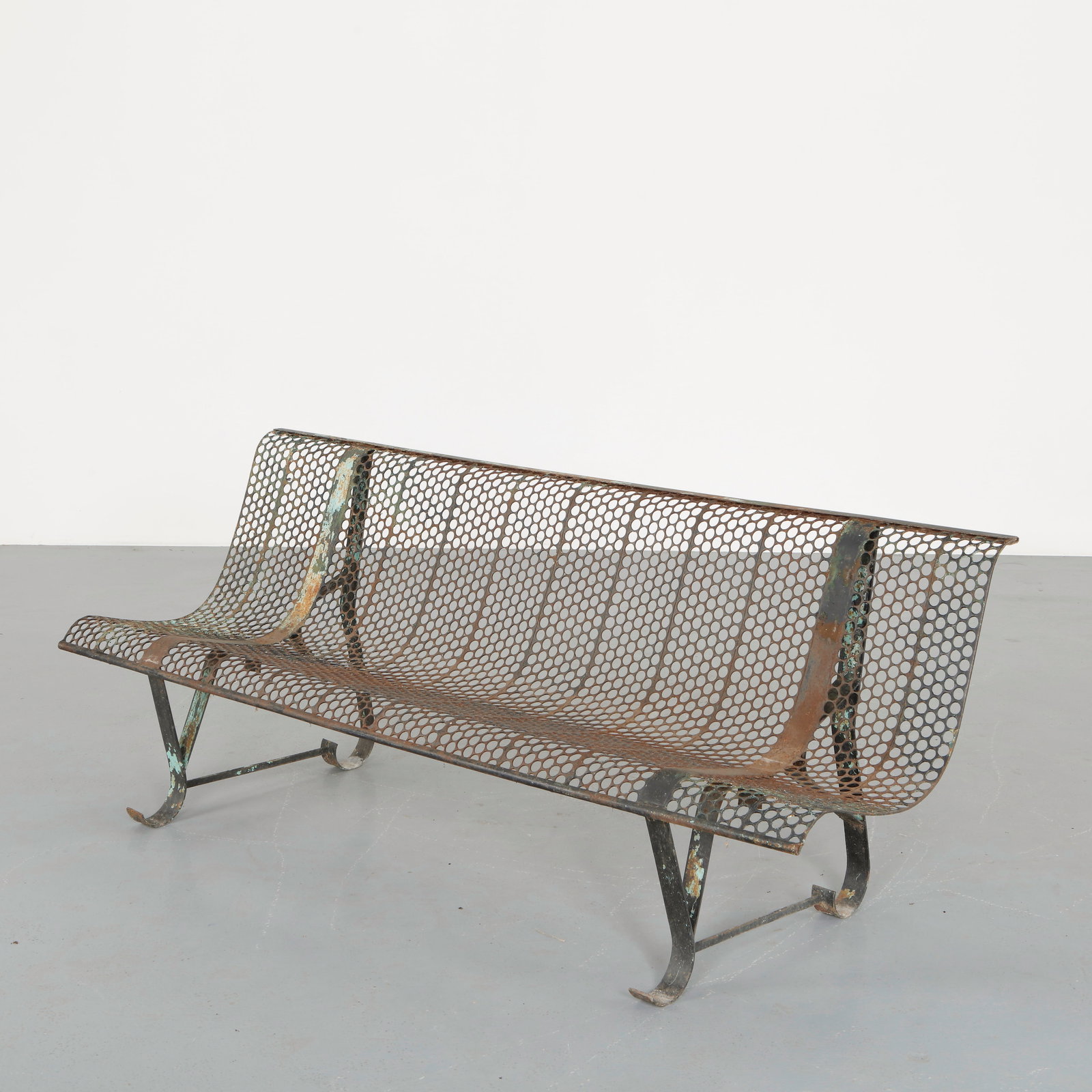 Rene Malaval, Perforated Metal Bench, 1950s: Constructed in perforated sheet metal forming a continuous curved seat and backrest. The rhythmic grid of circular perforations creates a light visual texture while ensuring durability for outdoor