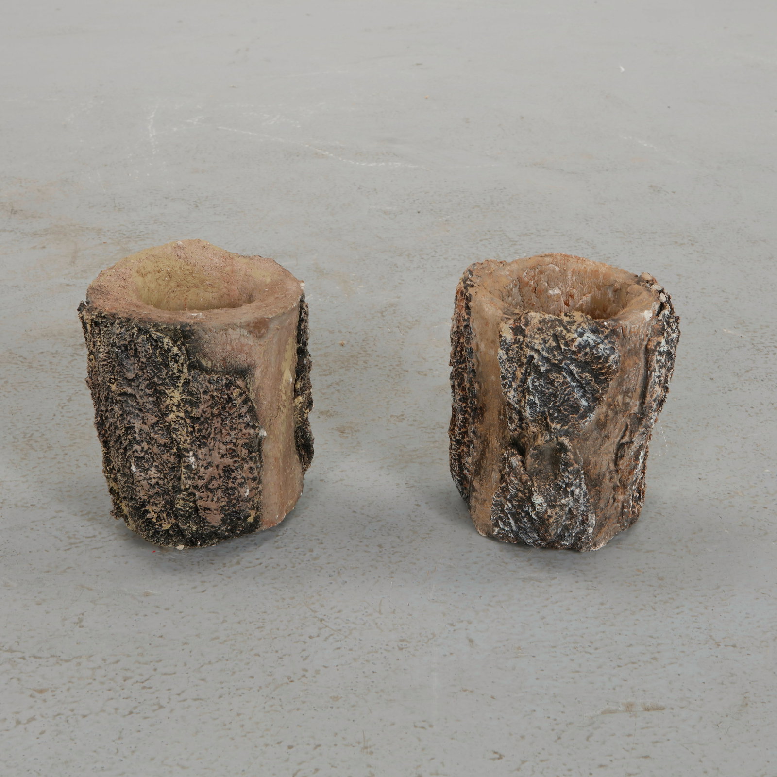 Pair of Round Faux Bois Planters, 1960s: Pair of sculptural planters modeled in textured faux bois imitating the irregular surface of tree bark. The organic cylindrical form and hand worked surface evoke rustic garden traditions while