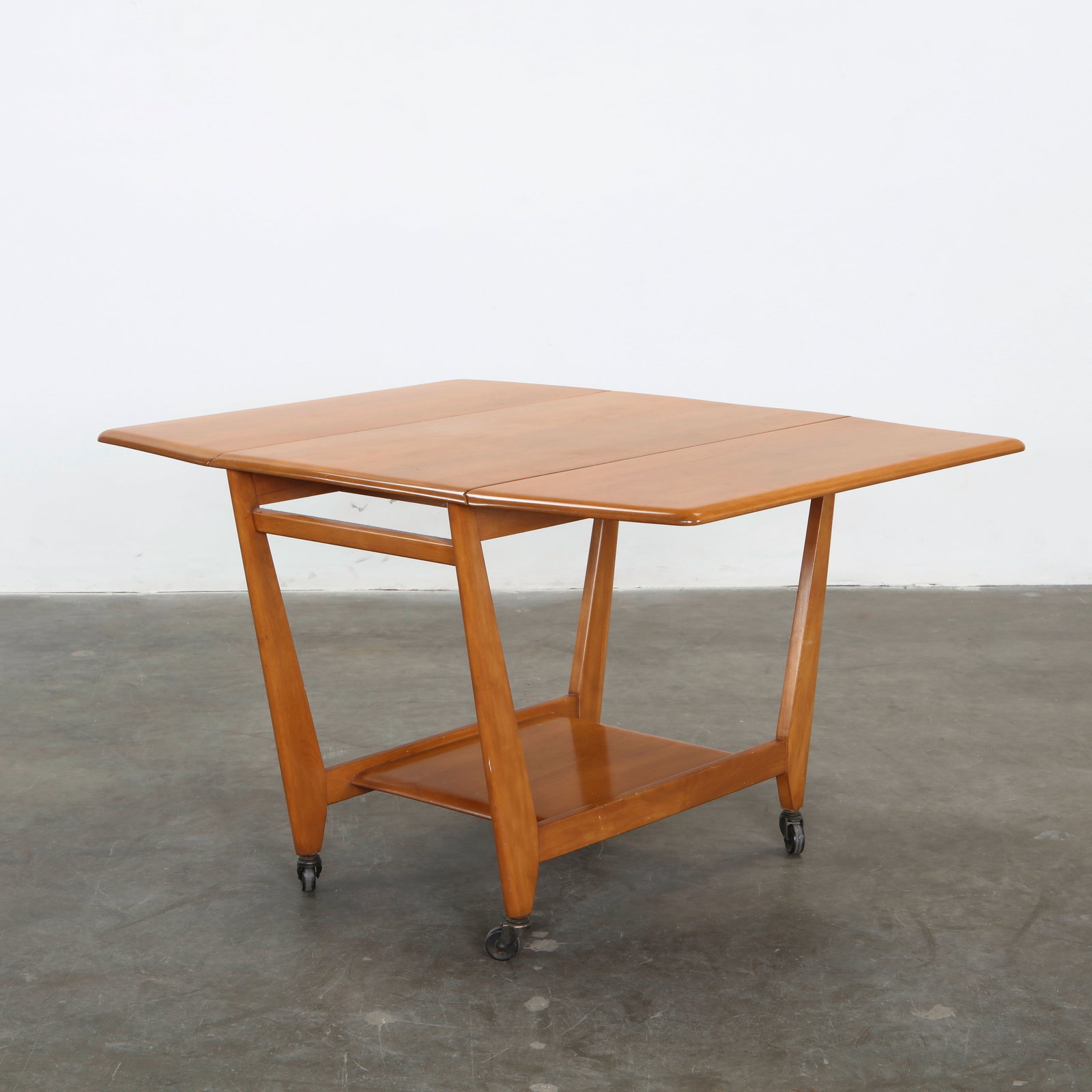 Heywood-Wakefield, Mid-Century Modern Drop-Leaf Dining Table, M394G, 1950s: Birch drop-leaf table on casters, merging flexibility and refined craftsmanship. Height: 28.5 in. Extended: Width: 48 in. Closed: Width: 22 in. Depth: 38 in.