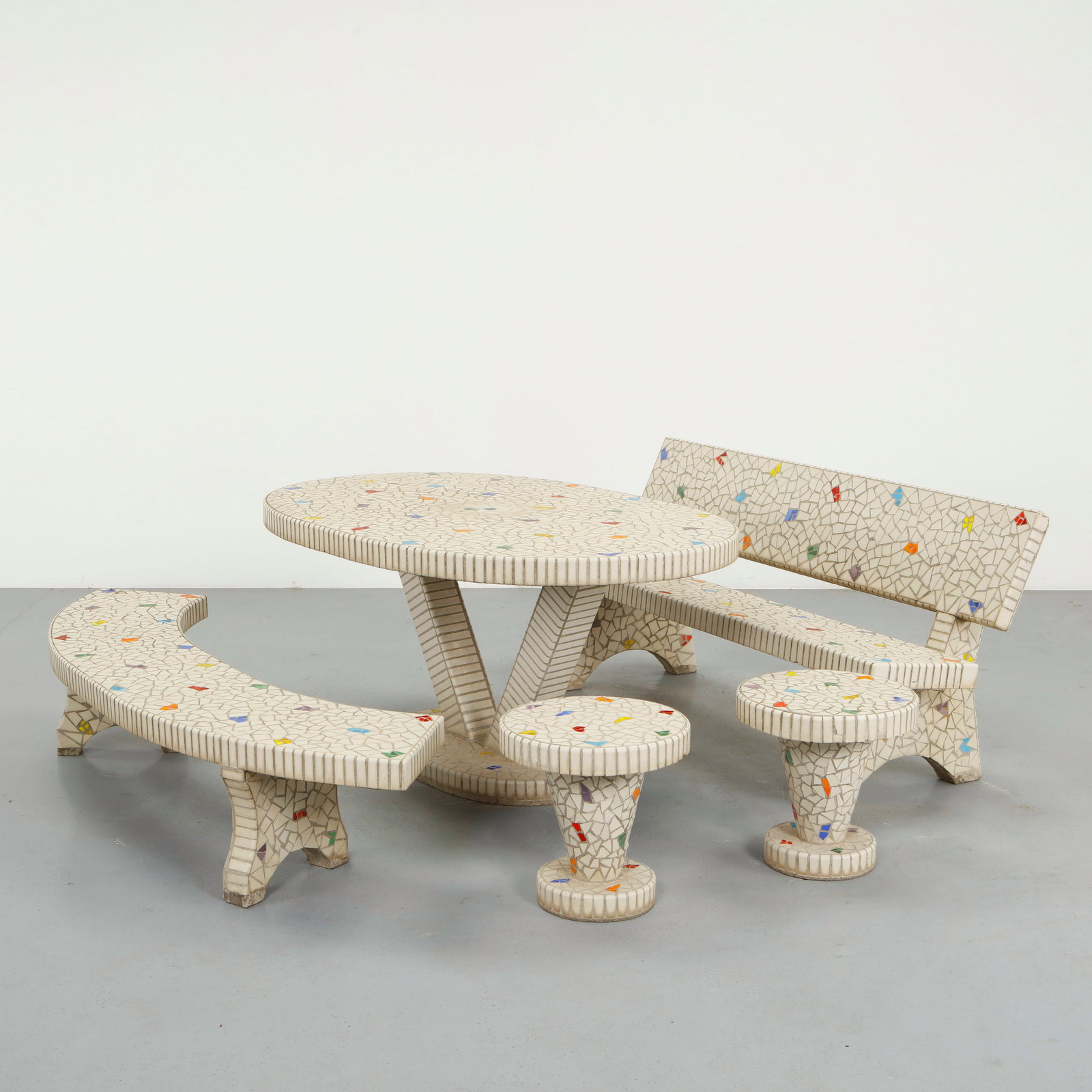 Mosaic Tile Outdoor Set, 1960s: Composed of hand-set ceramic mosaic on a pale ground, this ensemble is distinguished by its restrained palette punctuated with subtle polychrome inclusions. The curved bench and pedestal table demonst