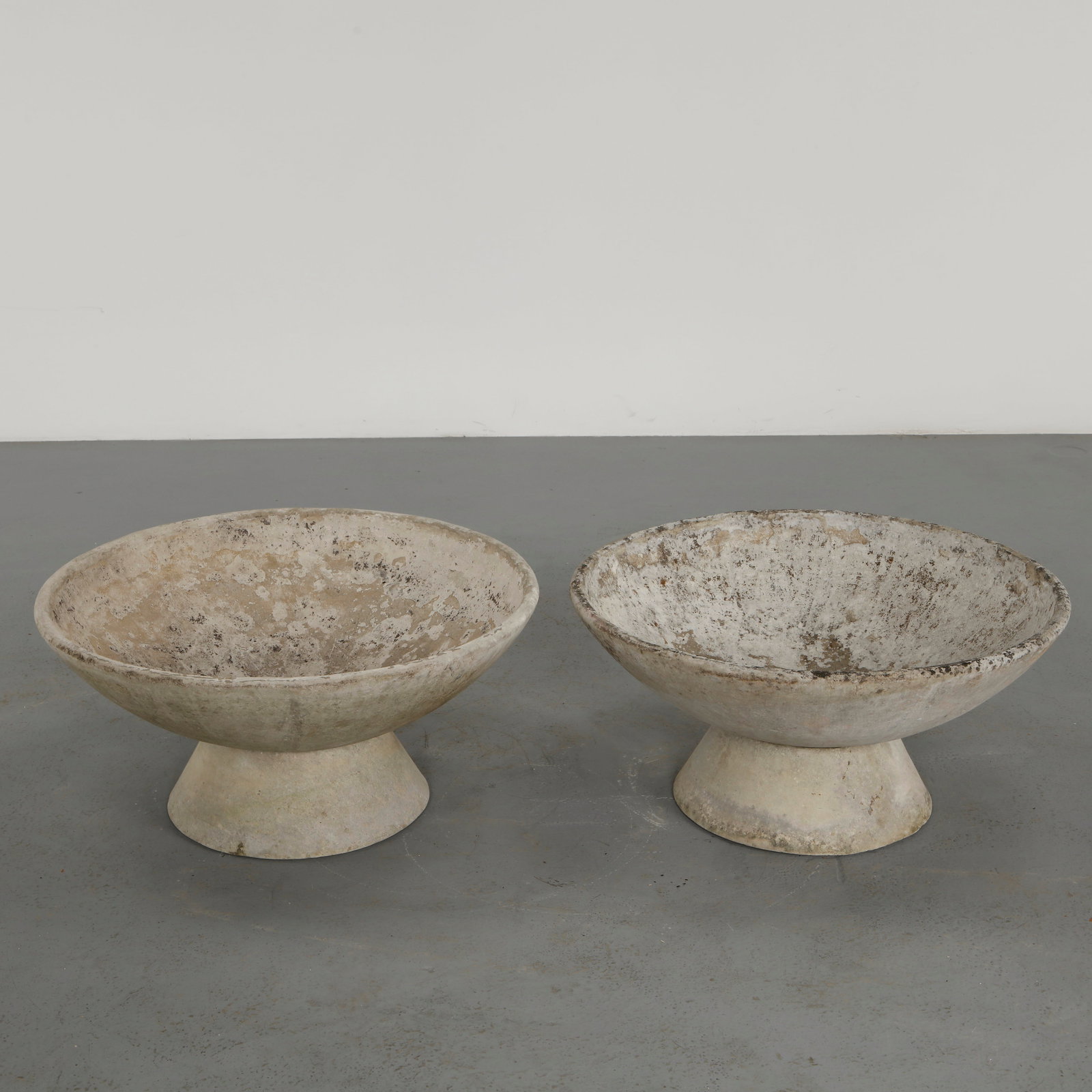 Willy Guhl, Pair of Bowl Planters, 1960s: Pair of round planters by Swiss designer Willy Guhl for Eternit, showcasing a magnificent patina. Elevated on their original concrete stands, creating a majestic and commanding presence. Height: 15