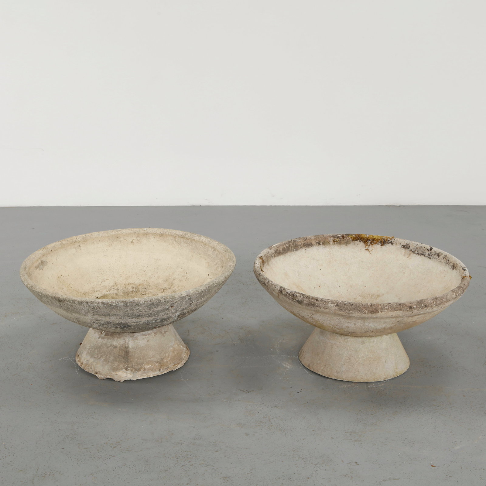 Willy Guhl, Pair of Bowl Planters, 1960s: Pair of round planters by Swiss designer Willy Guhl for Eternit, showcasing a magnificent patina. Elevated on their original concrete stands, creating a majestic and commanding presence. Height: 15