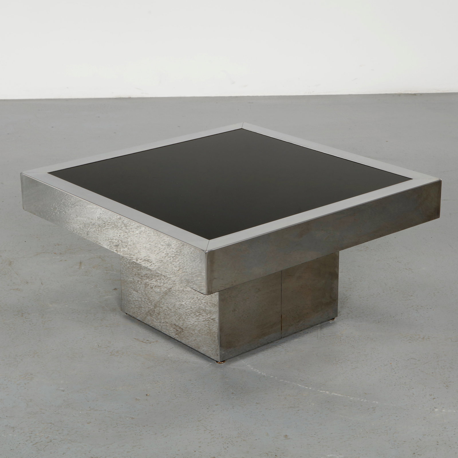 Willy Rizzo for Cidue, Glass and Stainless Steel Coffee Table, 1970s: A refined coffee table featuring a clear glass top set upon a geometric stainless steel base. The minimalist composition emphasizes balance and proportion, with a luminous interplay between transparen