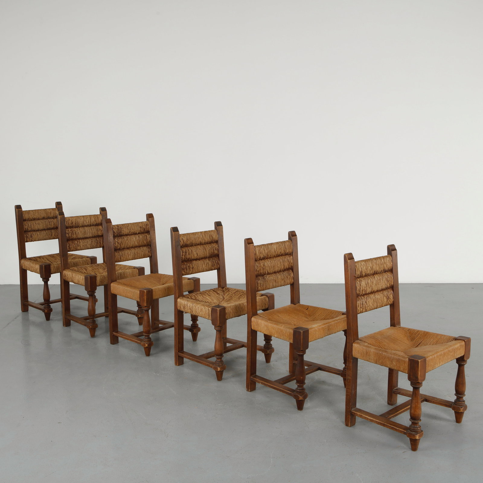 Charles Doudouyt, Set of Six Rope and Wood Chairs, 1940s: Constructed in stained wood with woven rope seats and backs, this set embodies a balance of rustic simplicity and modernist clarity. The interplay of natural fibers and structured frames recalls alpin