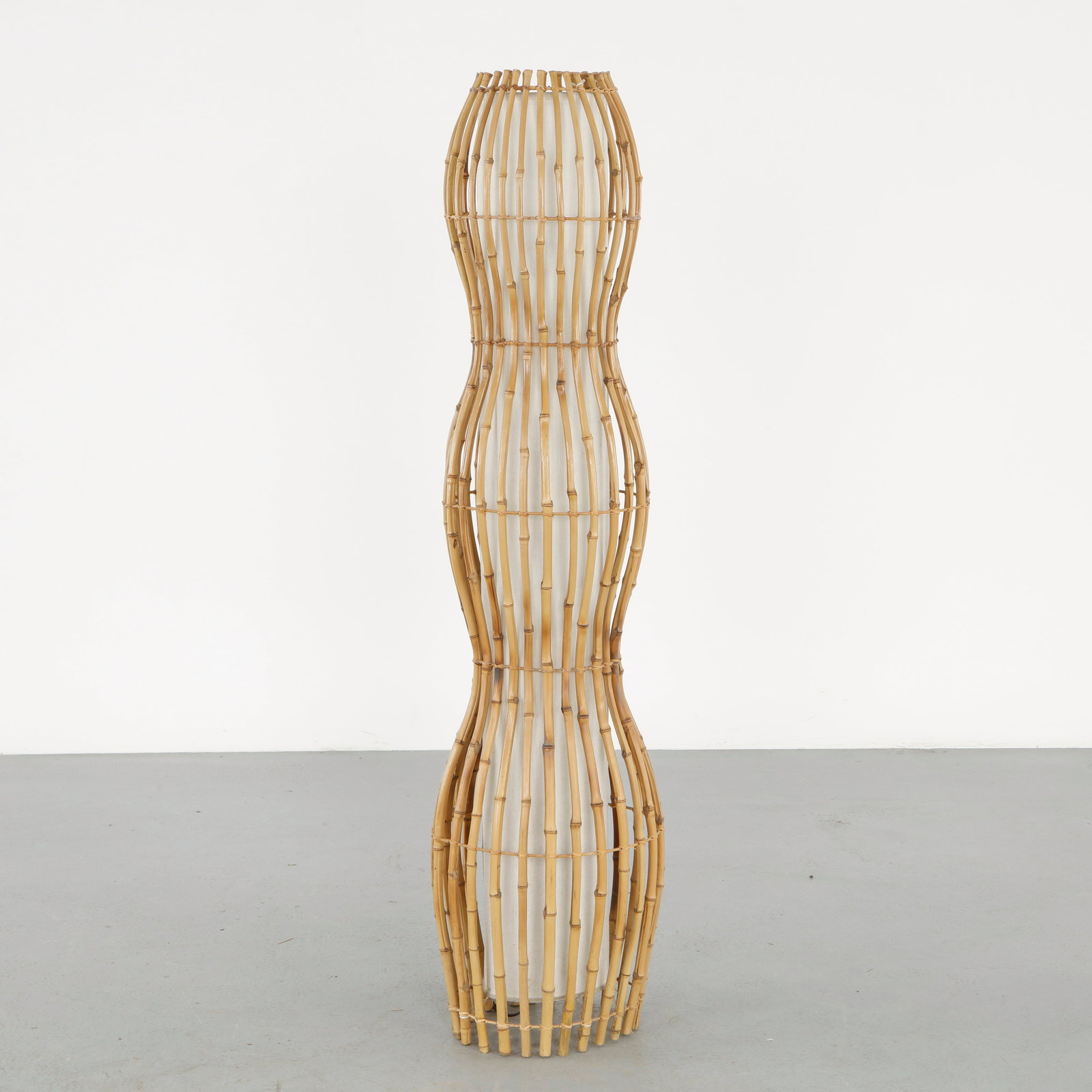 Italian Bamboo Floor Lamp in the style of Franco Albini, 1960s: Composed of bent bamboo elements forming a sinuous vertical silhouette, this floor lamp highlights the natural flexibility and rhythm of the material. The open structure creates a delicate interplay