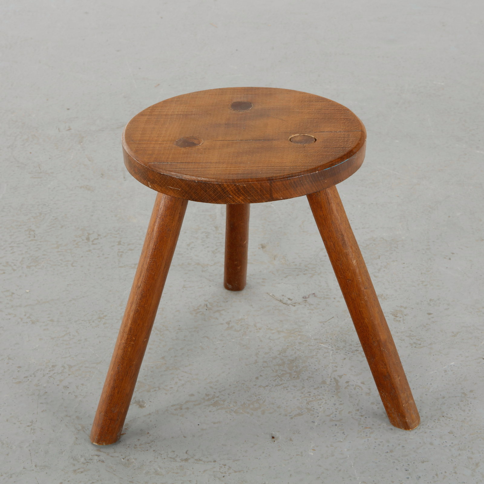 Brutalist Tripod Stool, 1960s: Low stool in solid wood with a thick rounded seat and three splayed legs, emphasizing stability and organic form. A timeless piece rooted in traditional craftsmanship. Height: 14 in. Diameter: 11 in.