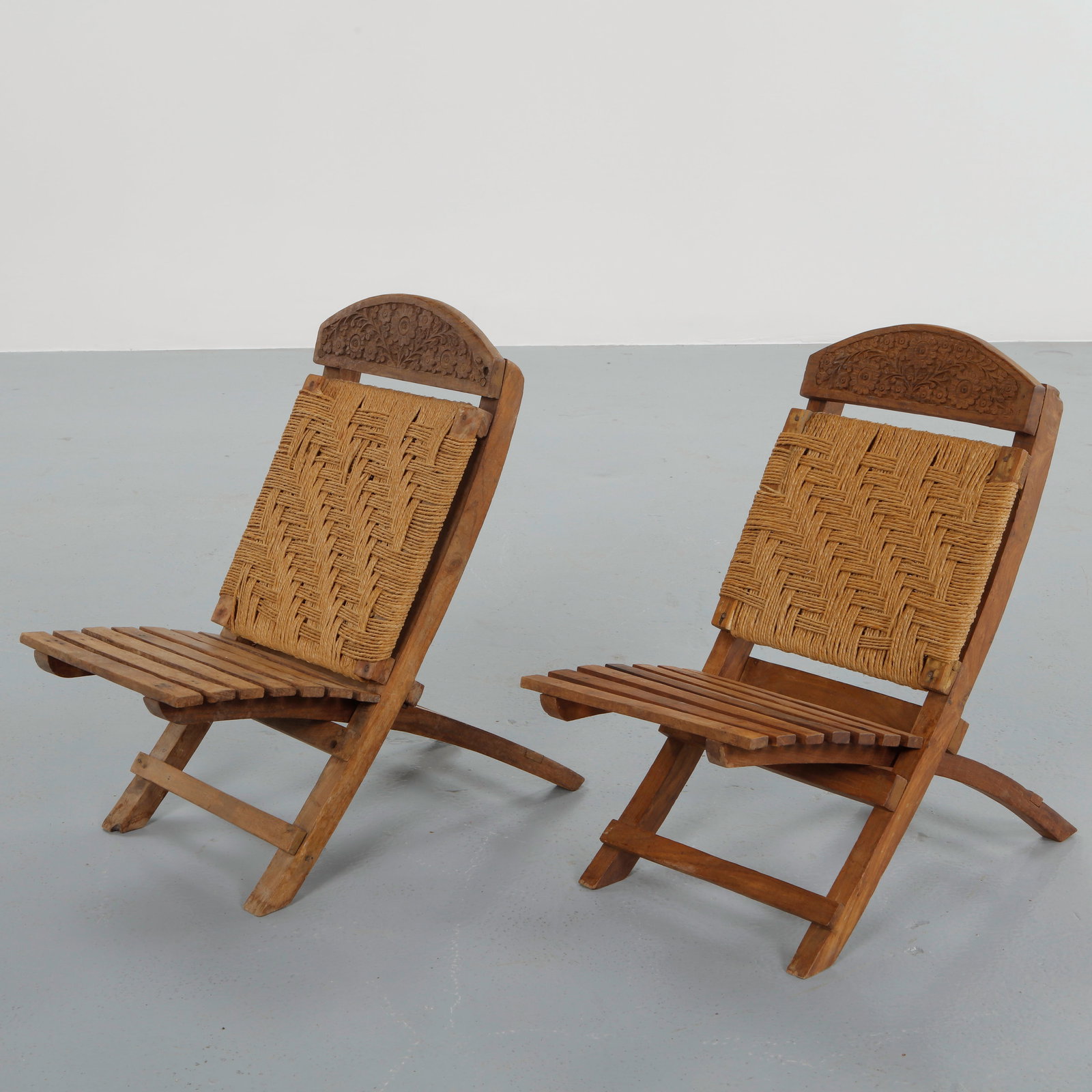 Pair of Brutalist Wood and Rope Chairs, 1960s: This pair of chairs is crafted in solid wood with woven rope seats, emphasizing bold lines and sculptural volumes. The expressive construction and tactile materials are characteristic of Brutalist