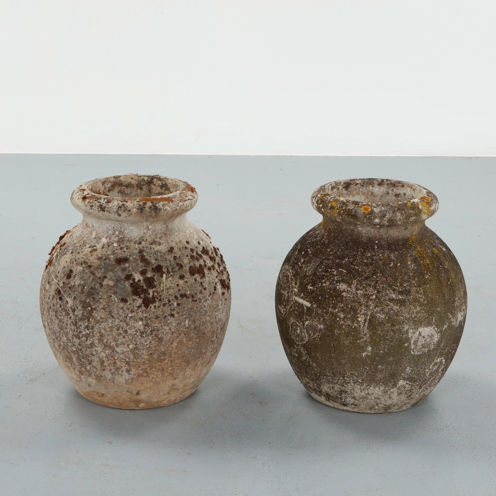 Willy Guhl, Pair of Jar Planters, 1960s: Crafted in fiber concrete with a generous rounded body and wide collar rim, these vessels bears a richly weathered surface with lichen and patina from decades of outdoor use. Height: 21 in. Diameter: