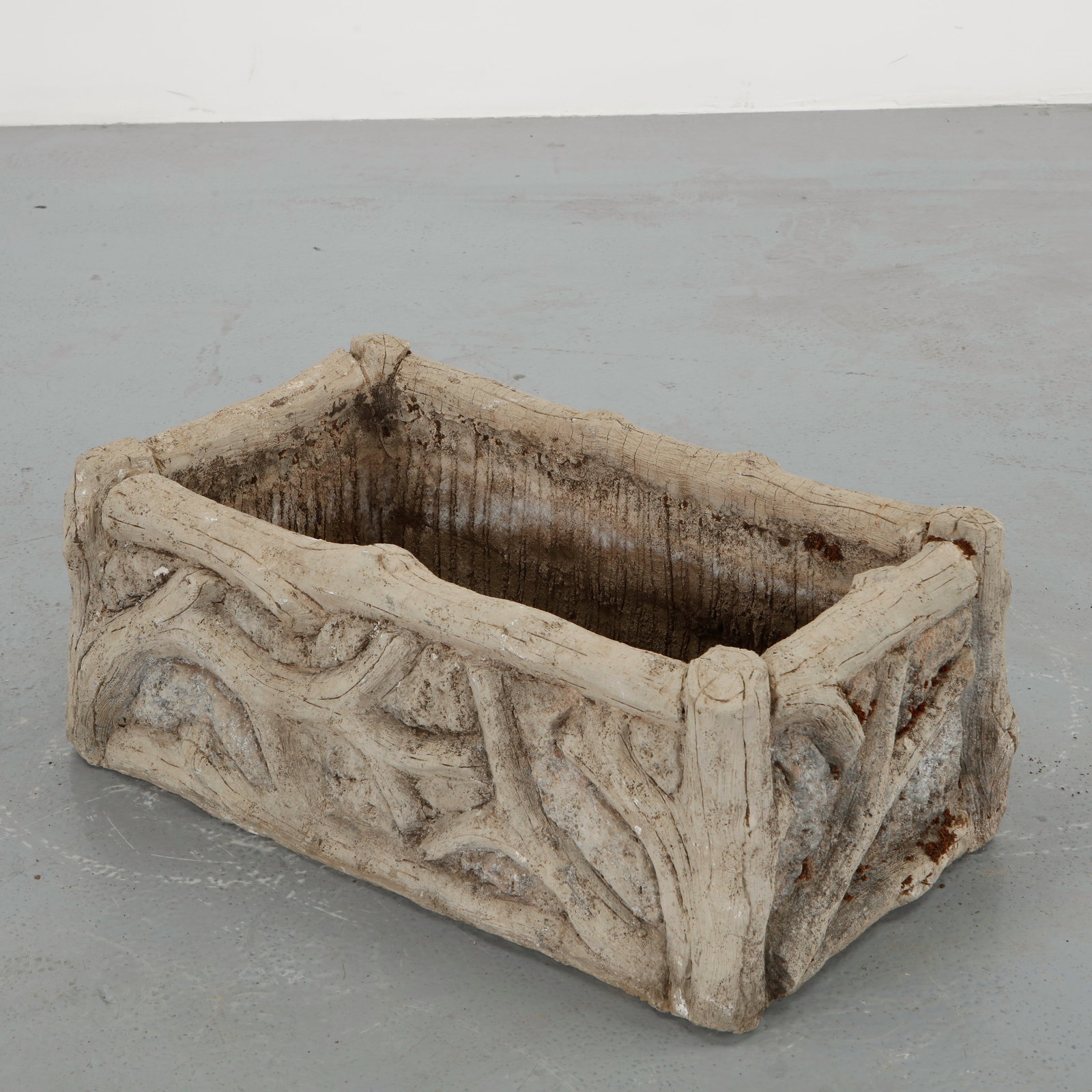Rectangular Faux Bois Planter, 1960s: Rectangular garden planter executed in cast concrete using the traditional faux bois technique. The exterior features sculpted branches and bark like textures arranged in a rhythmic decorative pattern
