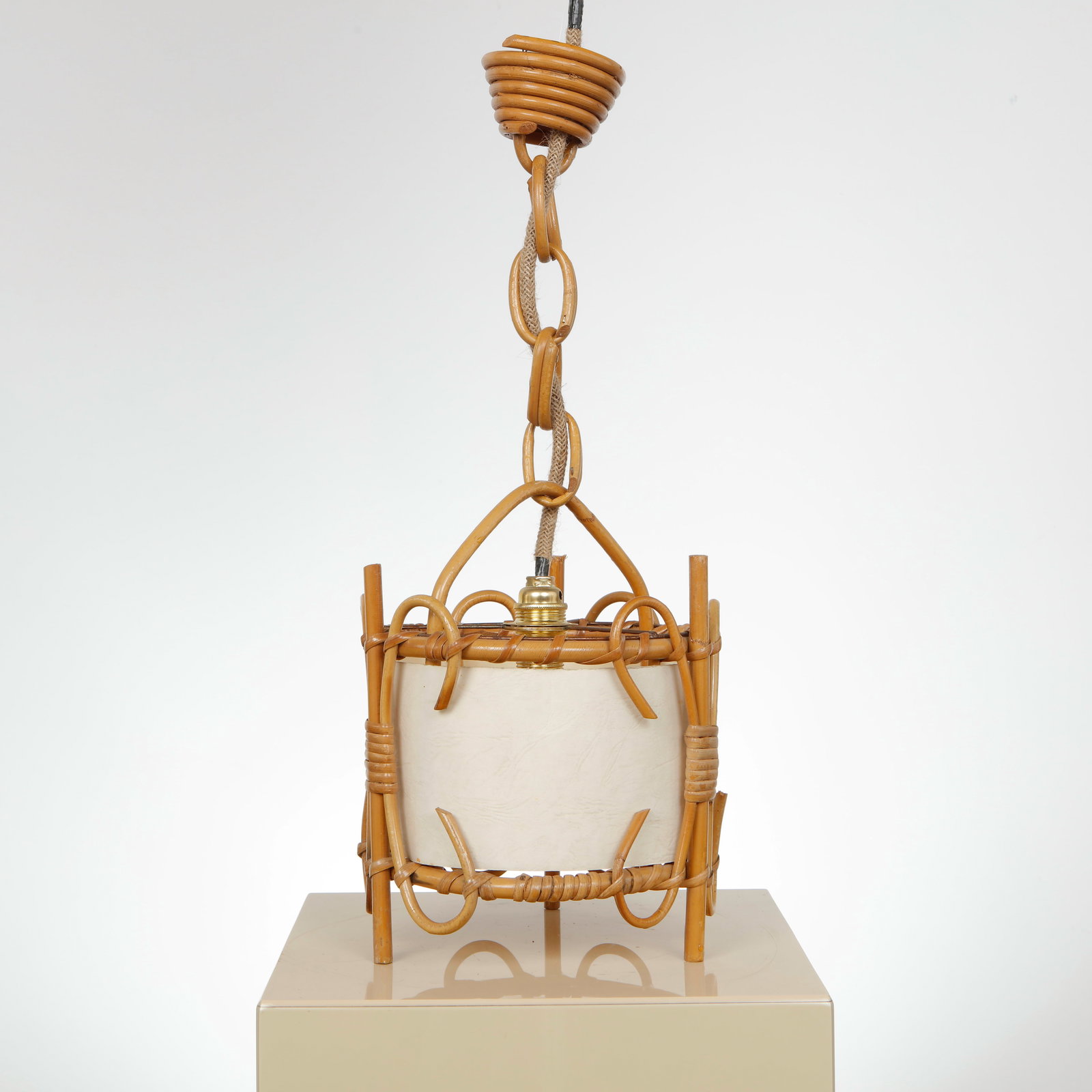 Louis Sognot, Light Fixture, 1960s: Pendant light crafted in bent rattan with sculptural curves and a central parchment diffuser. A balanced interplay of structure and softness, characteristic of French midcentury design. Height: 20 in.