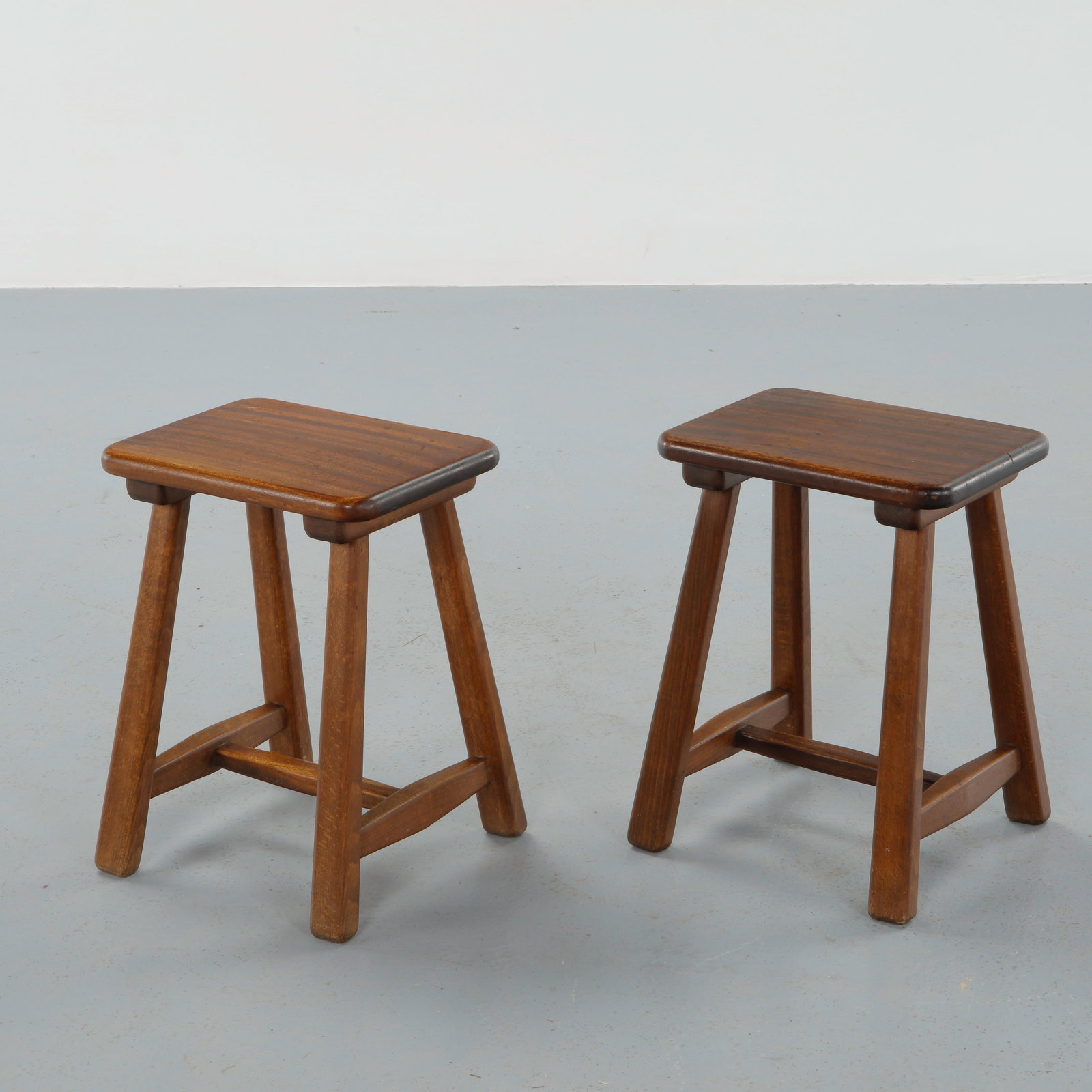 French Provincial, Pair of Solid Wood Rectangular Stools, 1960s: Executed in solid hardwood with gently rounded rectangular seats and sturdy square section legs joined by stretchers. The warm patina and restrained construction reflect honest craftsmanship and endur