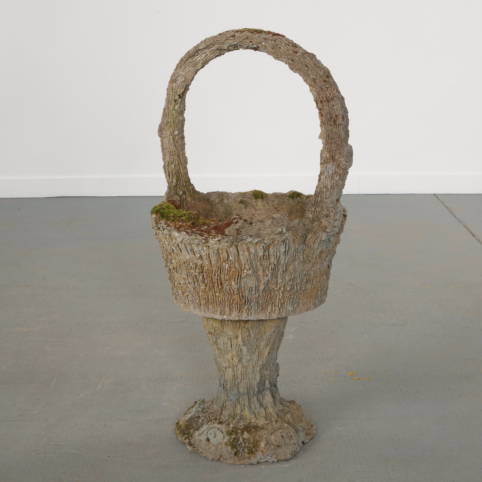 Monumental Concrete Basket Planter, 1960s: Large concrete planter executed in faux bois, featuring a basket form with integrated handle. An expressive example of postwar garden sculpture combining rustic ornament and scale. Height: 42.5 in.