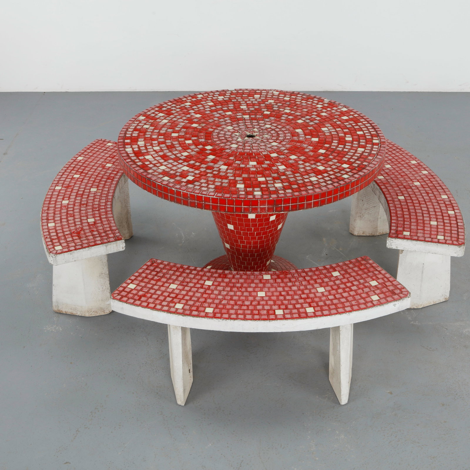 Red Mosaic Tile Dining Set, 1960s: A vibrant outdoor dining set featuring a circular table and integrated curved benches adorned with hand laid mosaic tiles. The vivid red tesserae create a dynamic radial pattern, set upon a sculptural