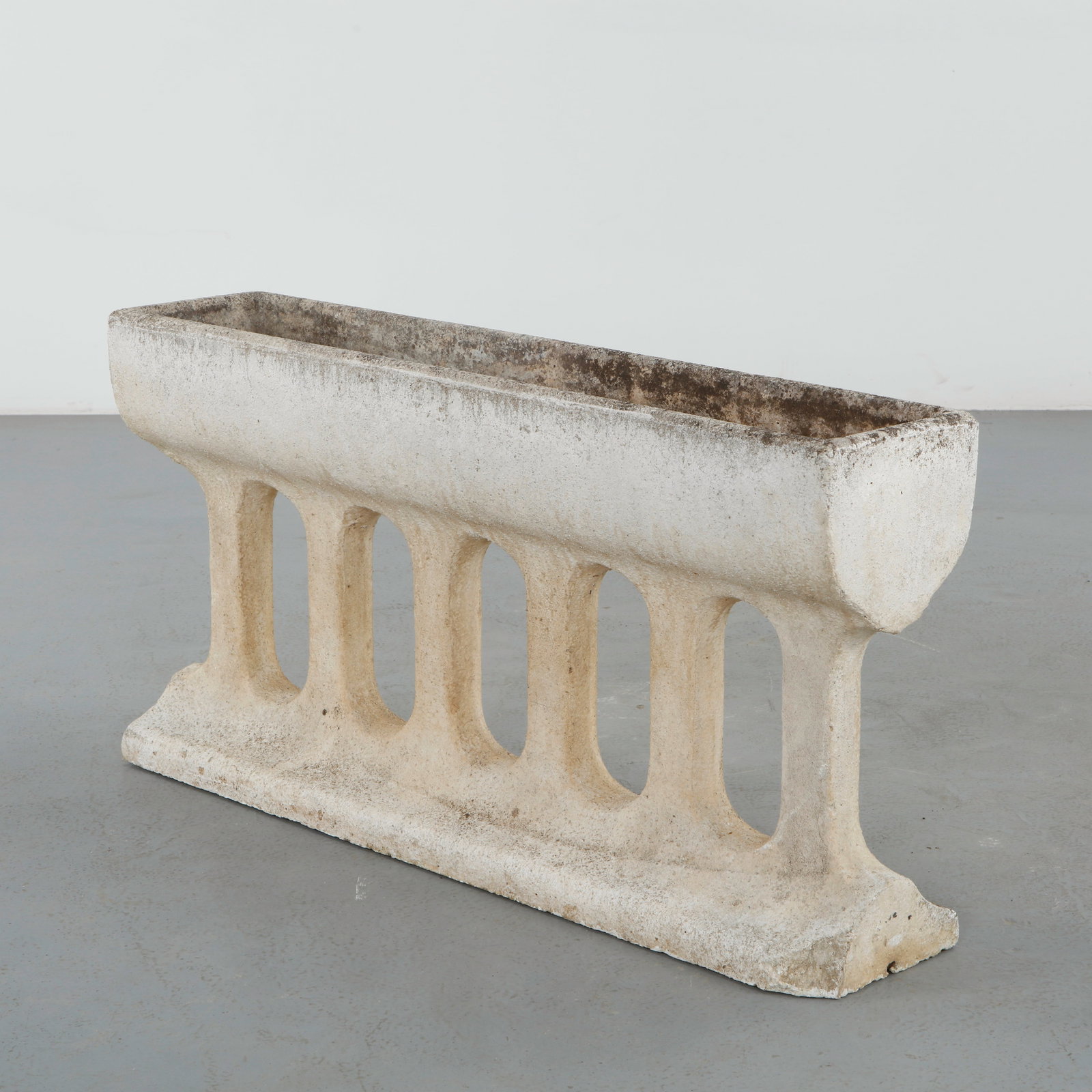 Architectural Stone Pillared Planter, 1960s: Architectural planter executed in carved stone with openwork balustrade-inspired detailing throughout the base. The textured surface and softened contours reveal decades of natural aging, enhancing it