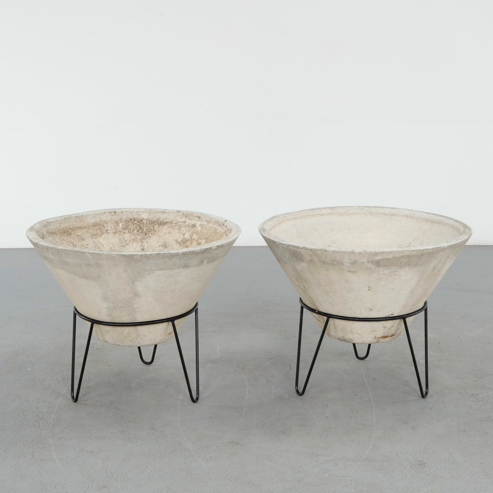 Willy Guhl, Pair of Large Conical Planters on Metal Stands, 1960s: Iconic Willy Guhl silhouettes in compact form, these conical planters rest atop minimalistic metal stands, weathered yet timeless. Height: 23 in. Diameter: 29.5 in.