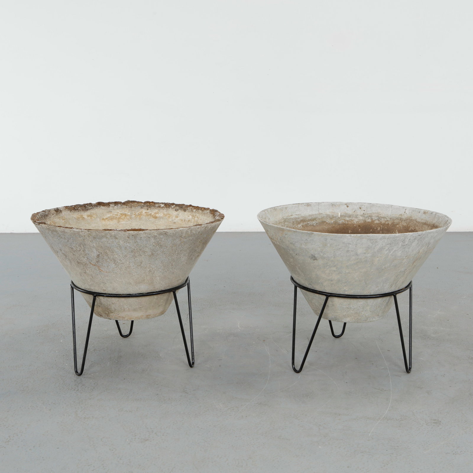 Willy Guhl, Pair of Large Conical Planters on Metal Stands, 1960s: Iconic Willy Guhl silhouettes in compact form, these conical planters rest atop minimalistic metal stands, weathered yet timeless. Height: 22.5 in. Diameter: 28.5 in.