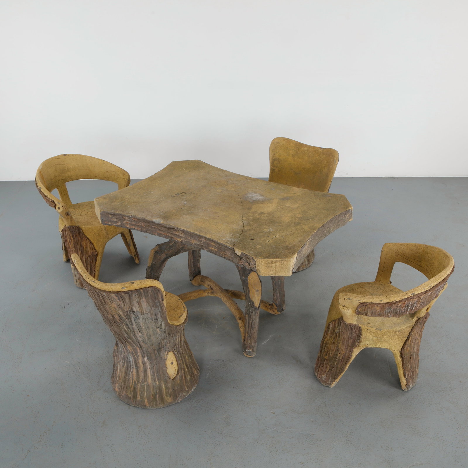 Faux Bois Garden Dining Set, France, 1960s: Rare faux bois garden dining set composed of a sculptural table and four matching chairs, executed in carved and stained concrete to imitate natural tree bark and cut timber. The organic silhouettes a