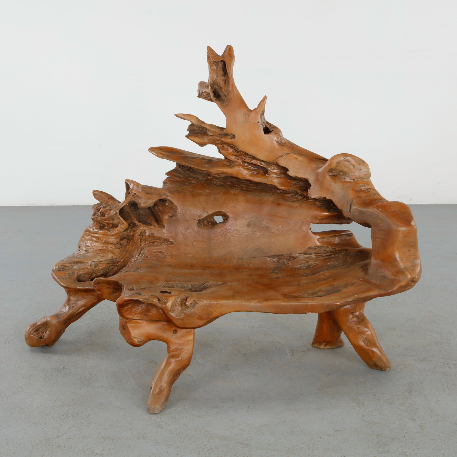 Outdoor Root Bench, 1960s: Sculptural outdoor bench carved from a monumental natural root formation with dramatic openwork contours and fluid organic lines. The polished wood surface reveals intricate grain patterns and natural