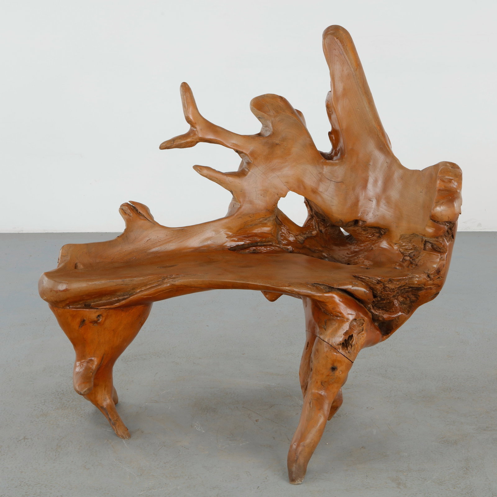 Outdoor Root Bench, 1960s: Expressive root wood bench executed with an asymmetrical silhouette and naturally formed sculptural backrest. The flowing composition and hand polished finish celebrate the raw beauty of organic