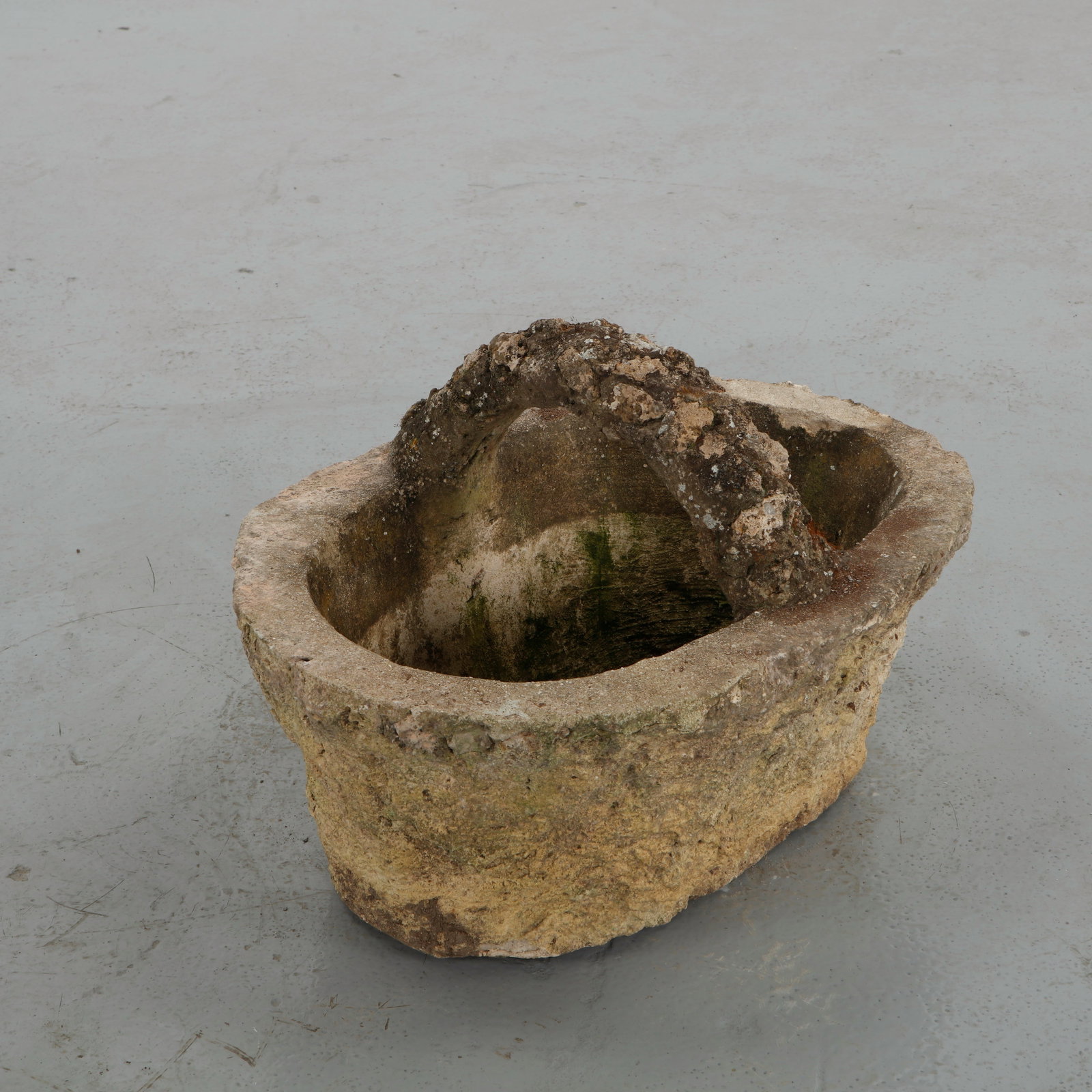Faux Bois Concrete Basket Planter, 1960s: Cast concrete planter executed in the traditional faux bois technique, imitating the texture and irregularity of natural wood. The arched handle and woven form evoke a rustic basket rendered in