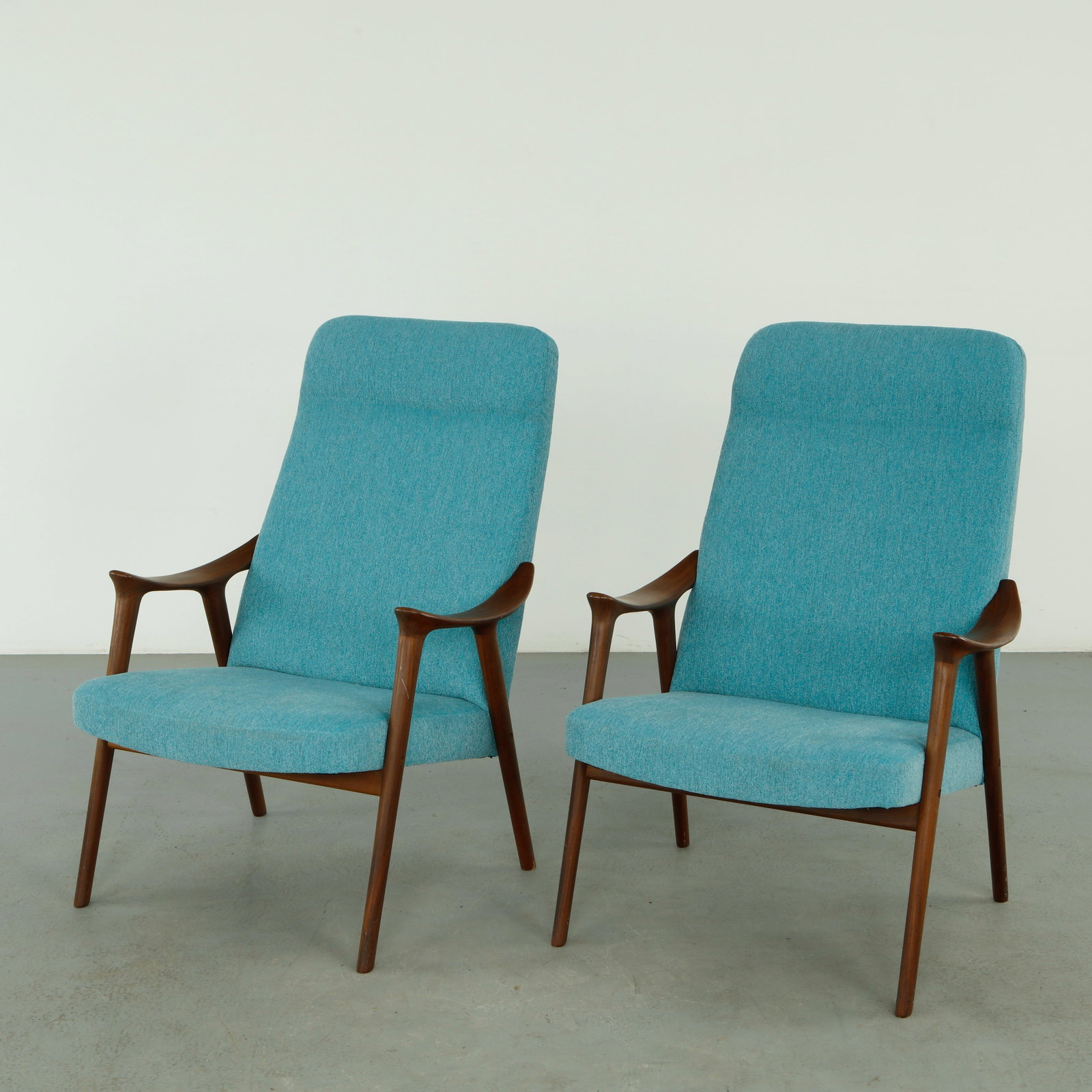 Rolf Rastad and Adolf Relling for More Lenestolfabrikk, Pair of Klarinett Chairs, 1960s: Executed in sculpted teak with elegantly curved armrests and tapered legs, upholstered in a textured blue fabric. A refined expression of Norwegian modernism combining comfort with architectural clari