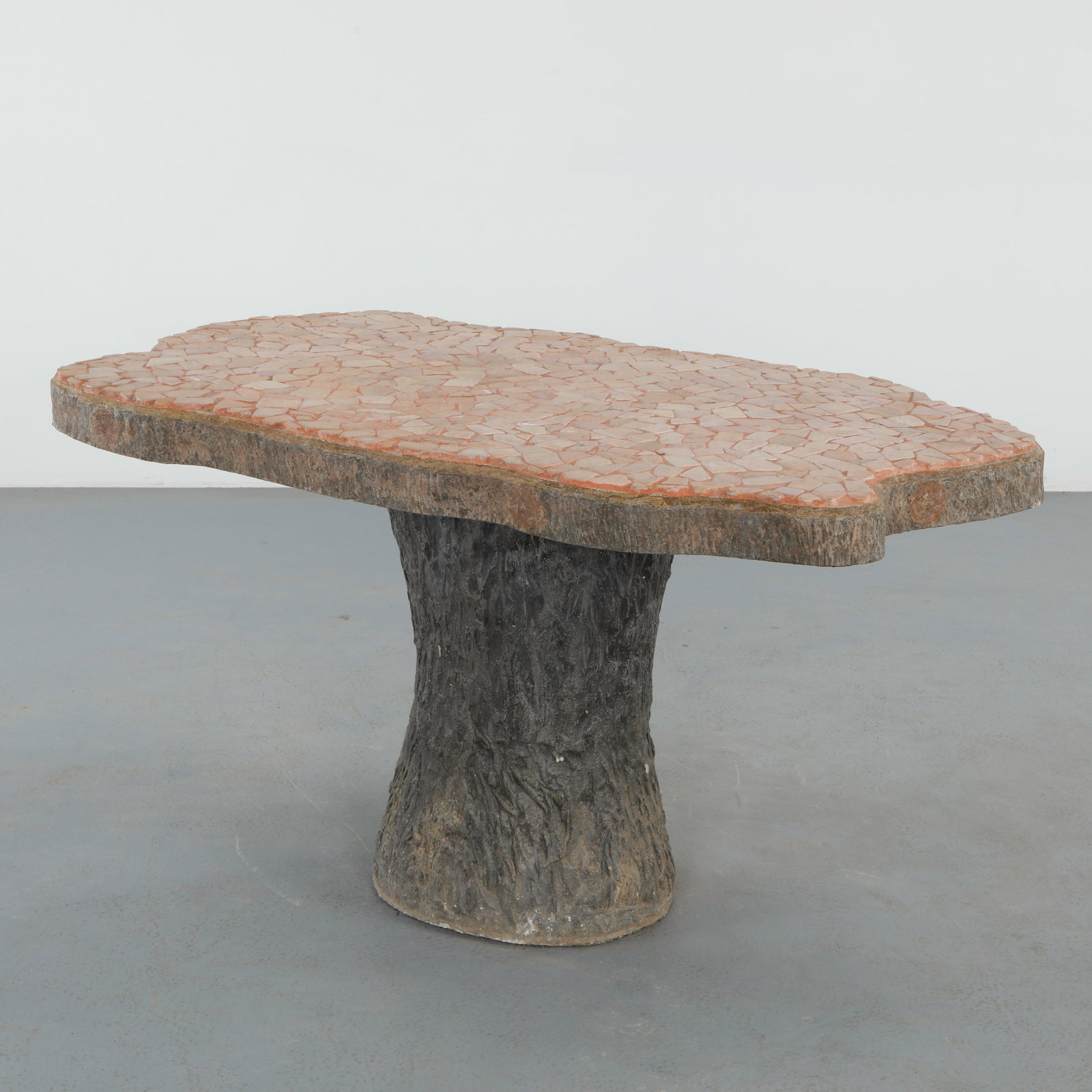 Faux Bois Mosaic Tile Dining Table, 1960s: A sculptural outdoor table executed in molded faux bois concrete, topped with a richly composed mosaic tile surface. The organic base contrasts with the fragmented geometry of the top, reflecting a