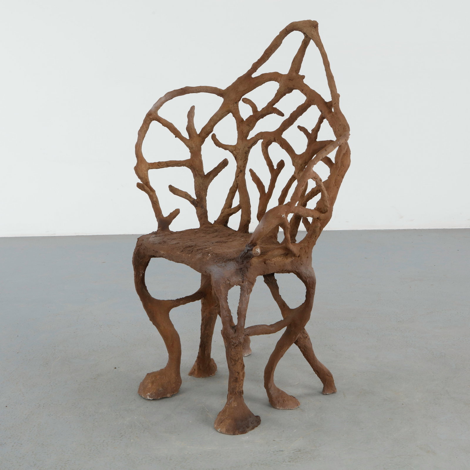 Architectural Faux Bois Armchair: Architectural faux bois armchair with a dramatic linear backrest composed of intertwined branch forms. The structured silhouette balances rustic naturalism with sculptural modernist sensibility. 