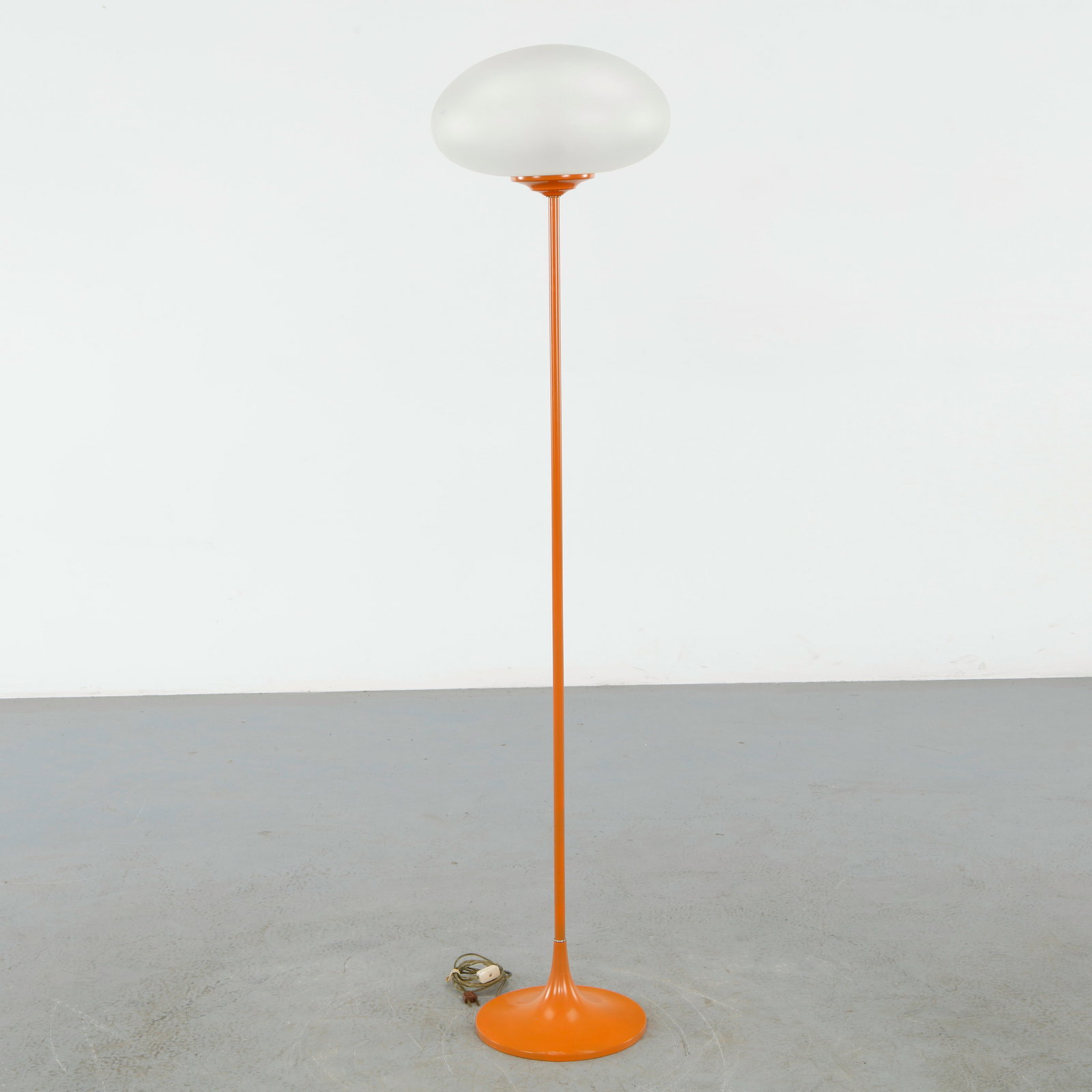 Designline, Stemlite Floor Lamp in Orange with Glass Shade: Composed of a slender orange stem rising to a rounded glass shade, creating a soft diffused light. A striking example of sculptural lighting from the American modern movement. Height: 55.5 in. Diamete