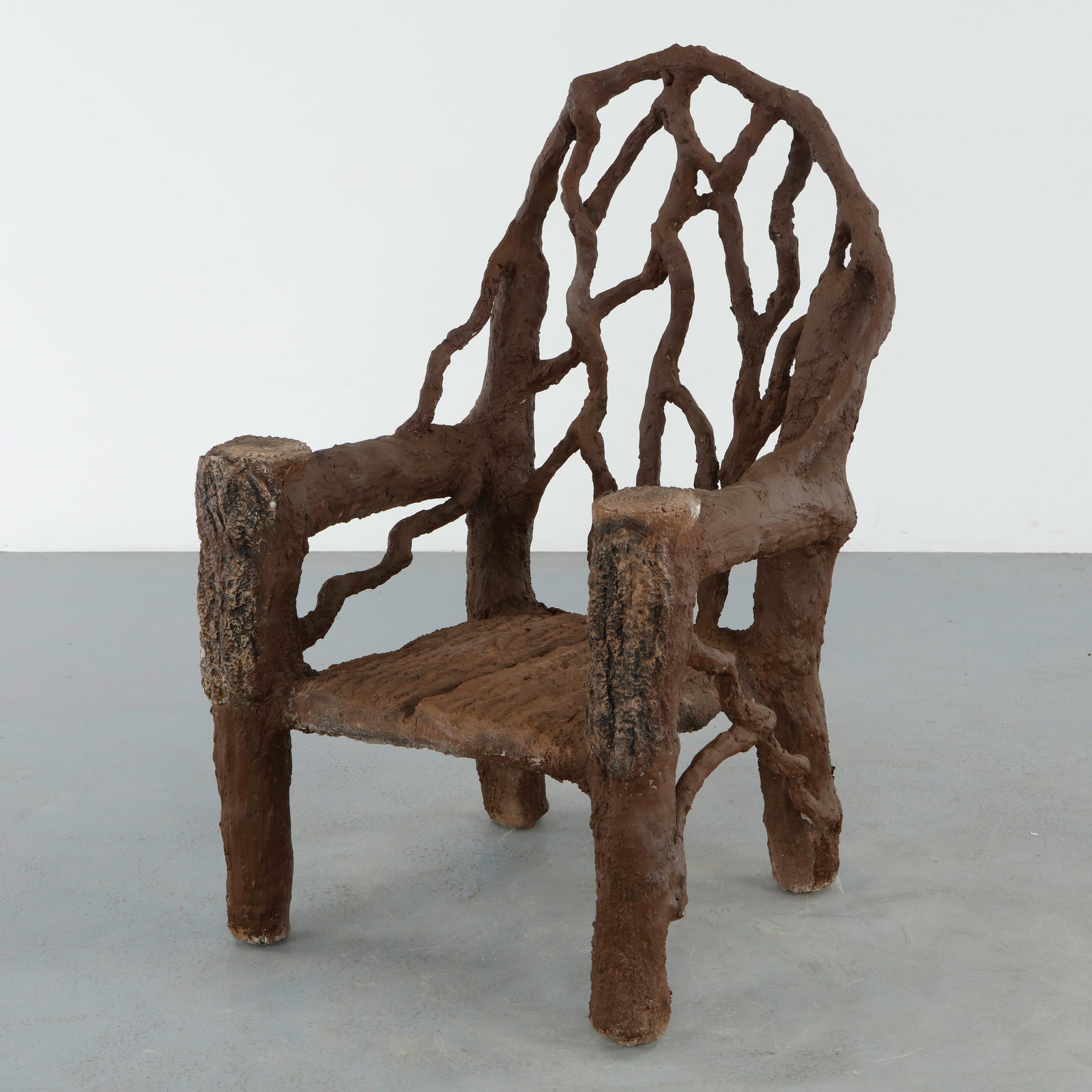 Monumental Faux Bois Sculptural Armchair: Monumental faux bois armchair executed with heavily textured bark like surfaces and an openwork organic backrest. The bold sculptural form embodies the expressive character of midcentury garden design