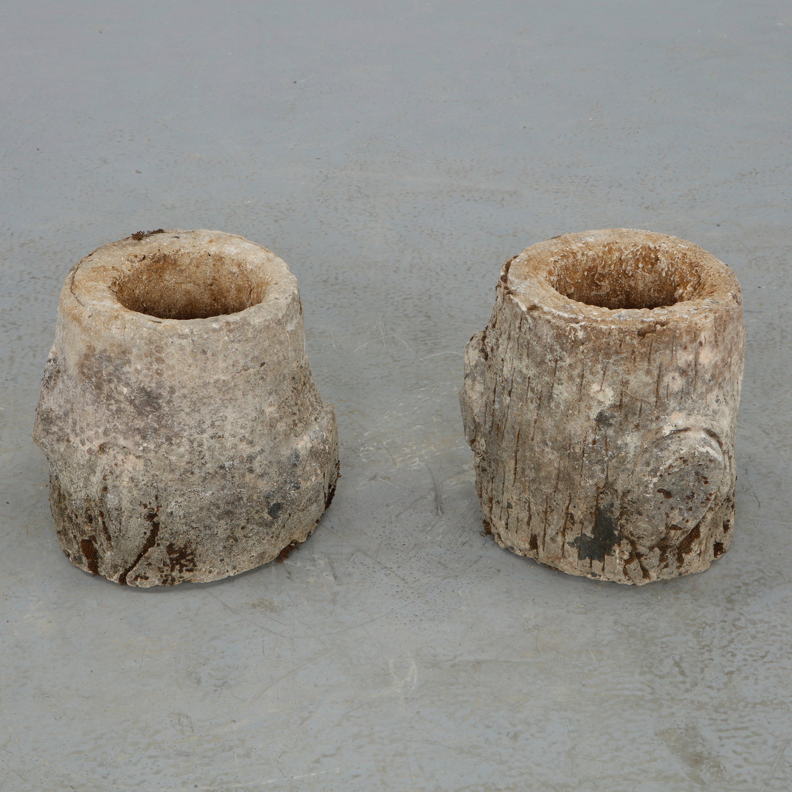 Pair of Round Faux Bois Concrete Planters, 1960s: Robust planters in faux bois concrete, distinguished by their cylindrical bodies and carved textures. The illusion of bark and natural irregularities reflects traditional craftsmanship within a modern