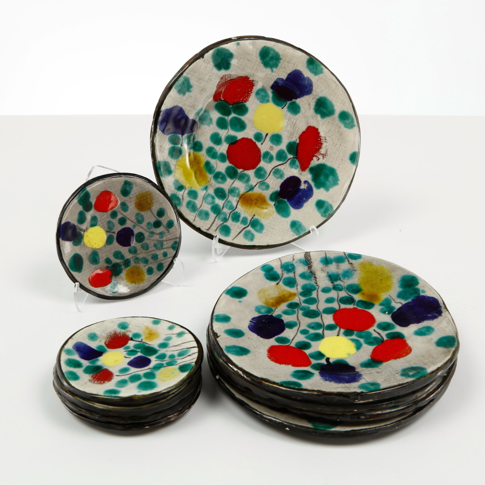 Keskar, Mid-Century Ceramic Plate Service, 1960: Hand painted ceramic plate service by Keskar, featuring vibrant abstract floral motifs in rich cobalt, vermilion, yellow, and emerald tones against a textured ivory ground. A lively example of French 