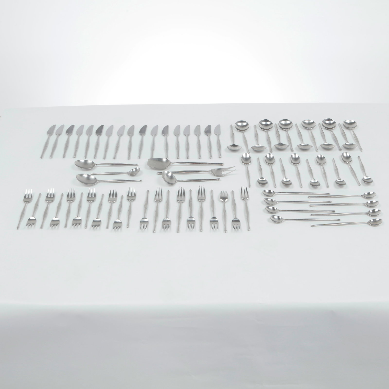 72-Piece Lauffer Design 3 Flatware Set, Norway, 1960s: Elegant modern stainless steel cutlery service executed with slender tapering handles and a restrained organic silhouette characteristic of midcentury Nordic design. The service includes 10 pastry for