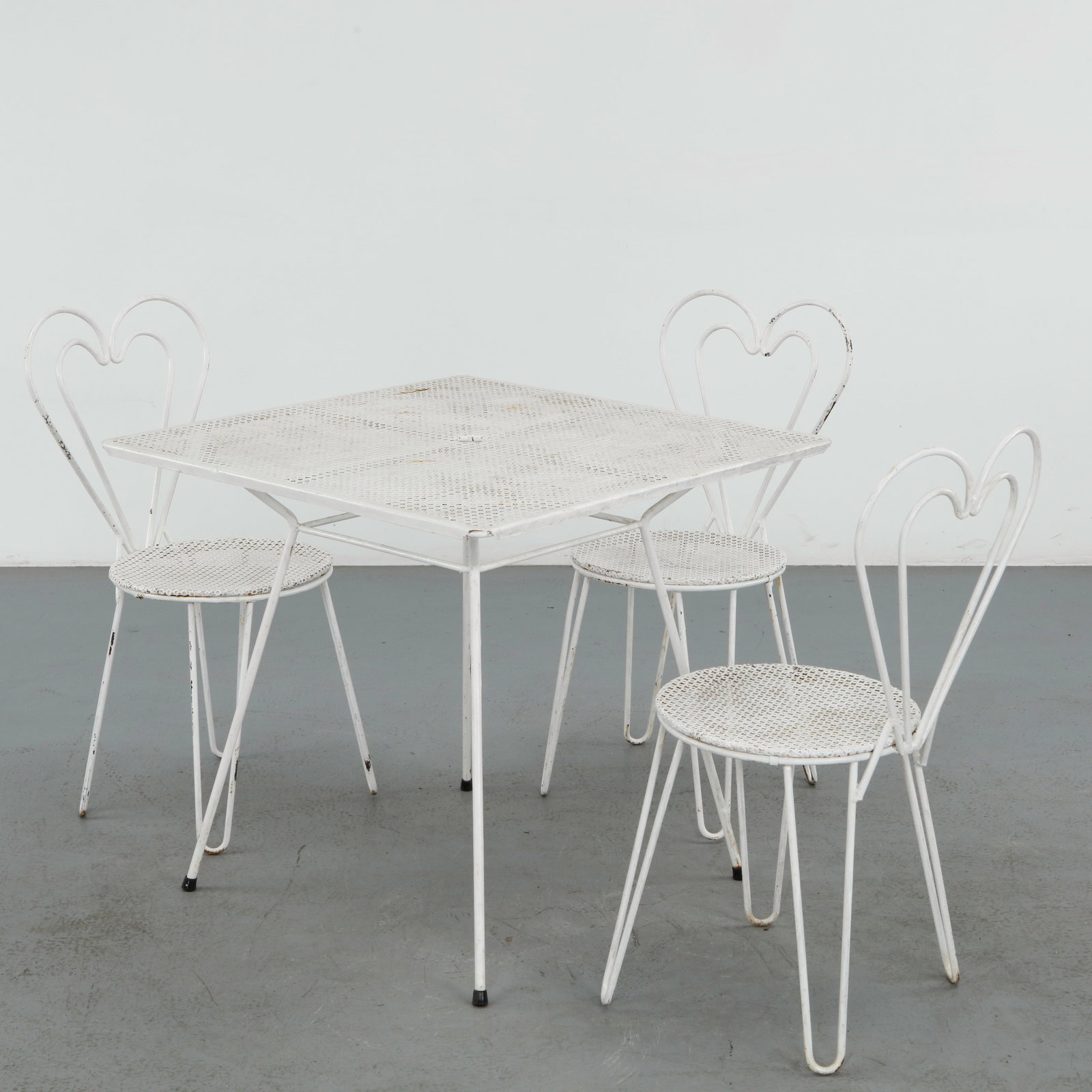 Mathieu Mategot, Metal Outdoor Dining Set, 1950s: Elegant outdoor dining set attributed to Mathieu Mategot, executed in perforated lacquered metal with the designer iconic rigitulle technique. The sculptural heart shaped chair backs and airy geometri