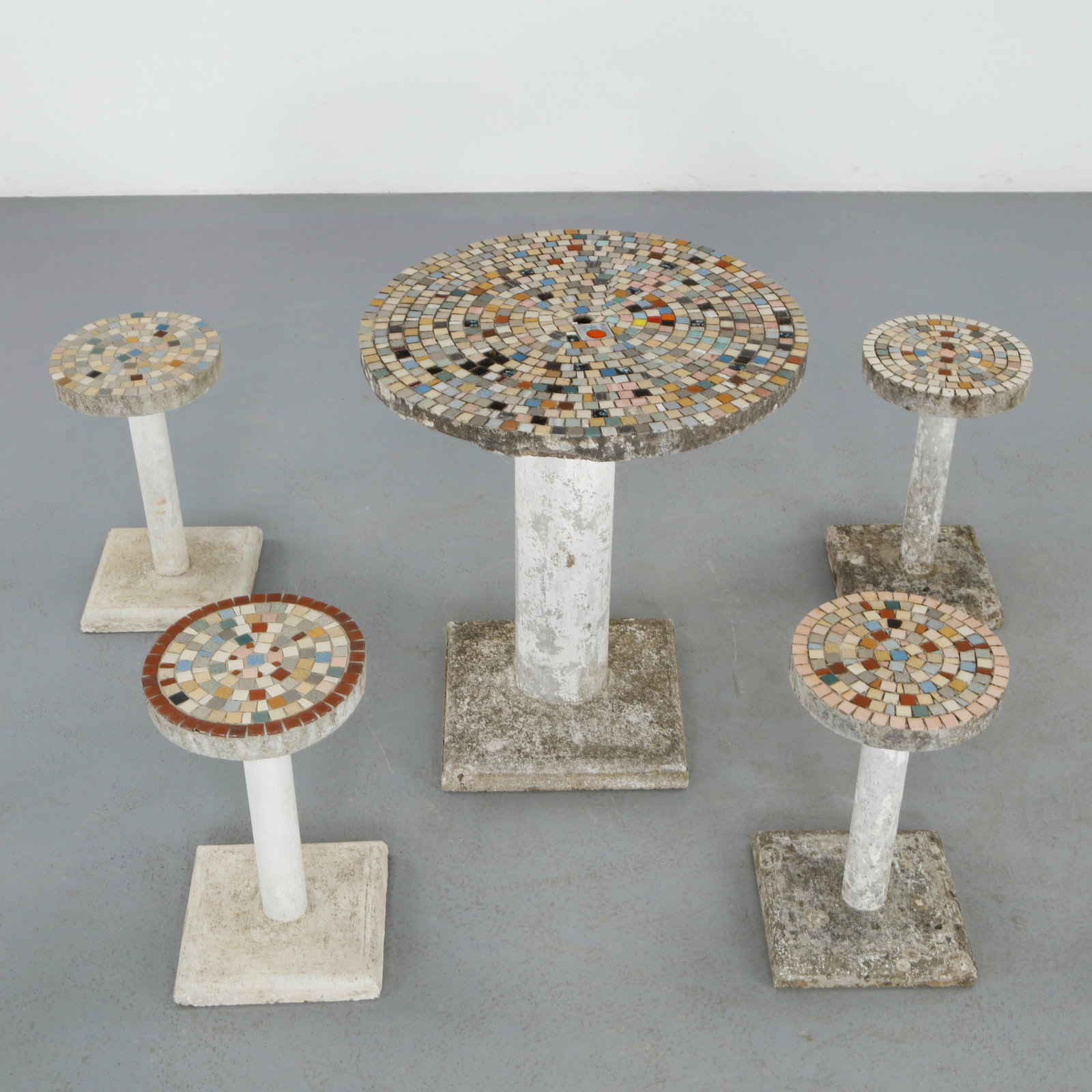 Mosaic Outdoor Bar Set, 1960s: A vibrant outdoor bar set composed of a central pedestal table and matching stools, all adorned with hand laid mosaic tiles. The dynamic polychrome surface reflects artisanal craftsmanship and midcent