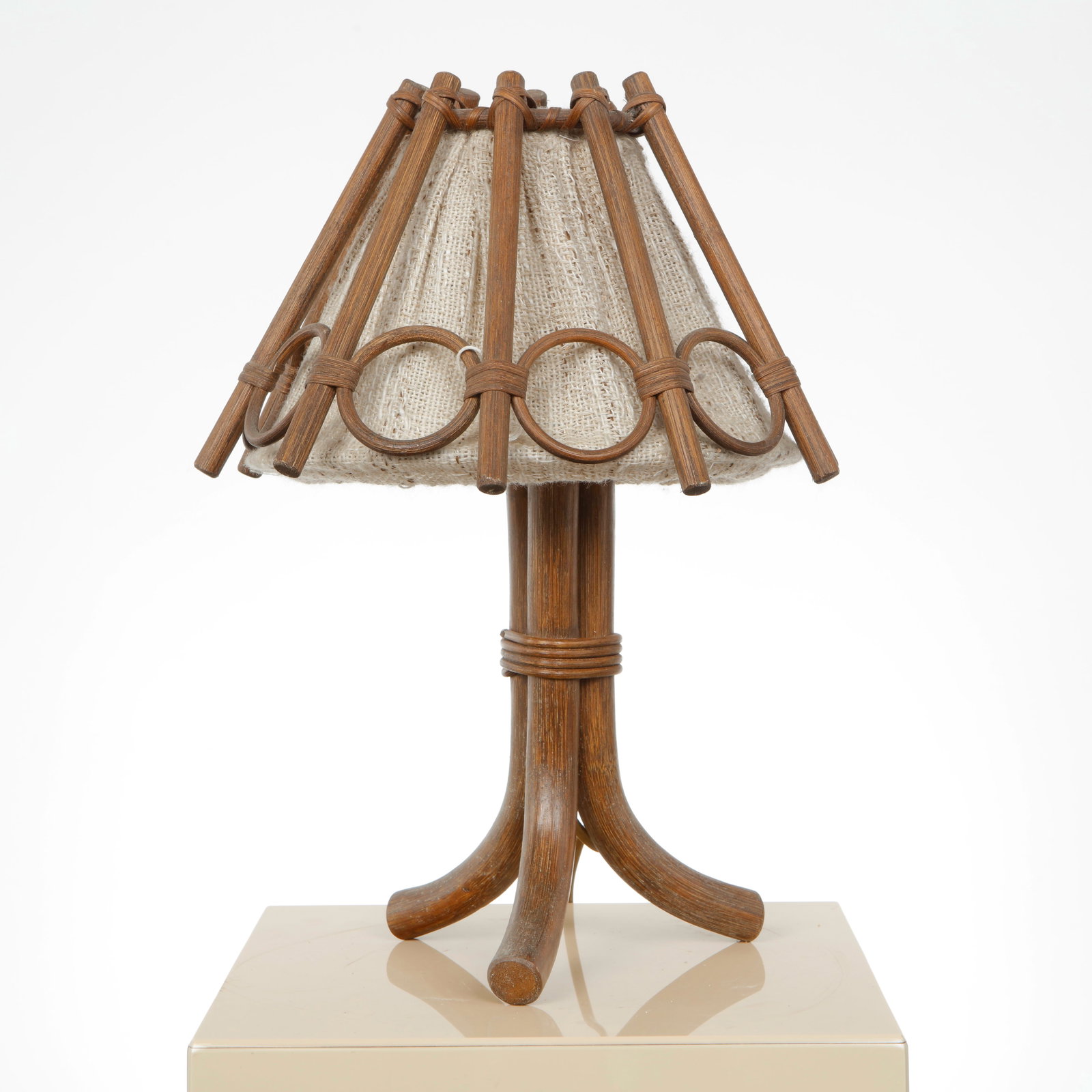 Louis Sognot, Table Lamp, 1960s: Compact table lamp in rattan with a sculptural base and ringed decorative elements supporting a fabric shade. A refined example of SognotÃ¢â‚¬â„¢s elegant and functional design vocabulary. H