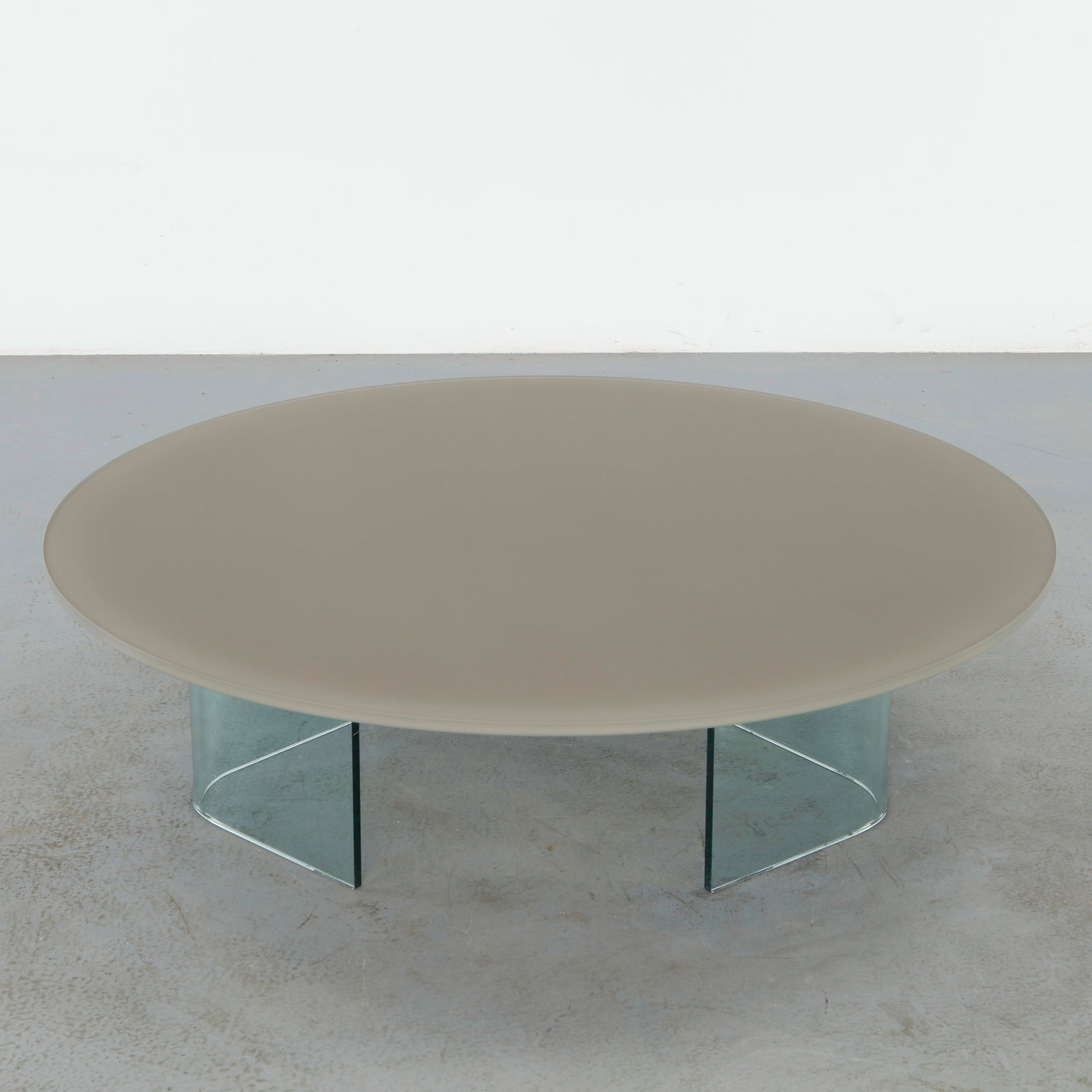 GLAS Italia Lindos Round Tinted Glass Coffee Table: Featuring a circular tinted glass top supported by sculptural bent glass legs, executed with precision craftsmanship. A refined contemporary design emphasizing transparency and lightness. Height: 14.5