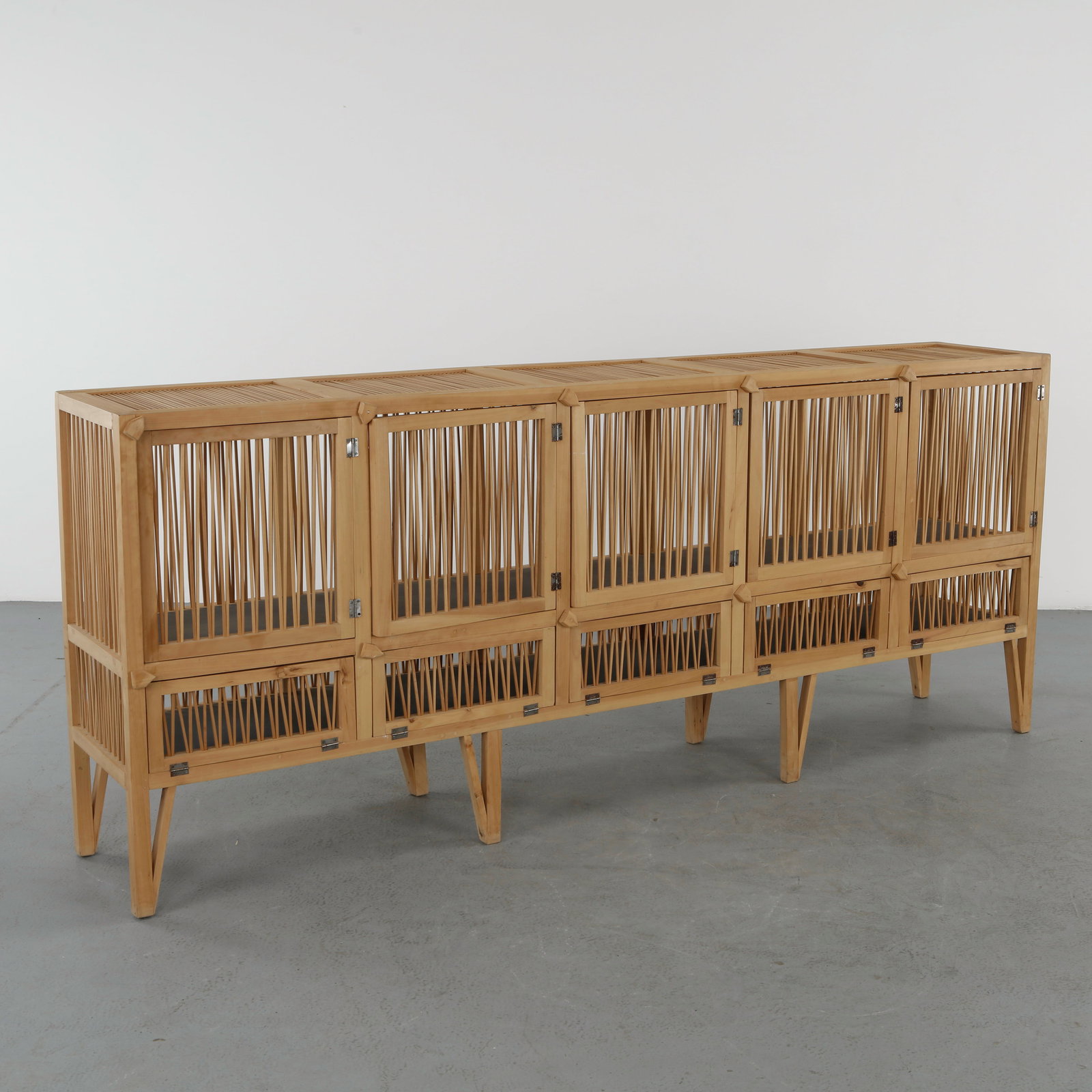 Large Wood Sideboard, 1960s: Featuring an elongated form with slatted doors and a raised structure on tapered legs. The clean lines and natural materiality reflect mid century modern craftsmanship. Height: 39.5 in. Length: 96 in.