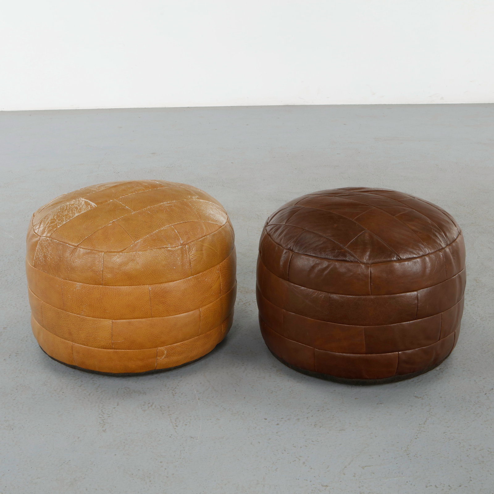 DeÂ Sede, Pair of Leather Ottomans, 1960s: Executed in hand-stitched patchwork leather, these sculptural ottomans exemplify DeÂ Sede signature craftsmanship and supple upholstery. Their brown and camel tones and generous forms invite both