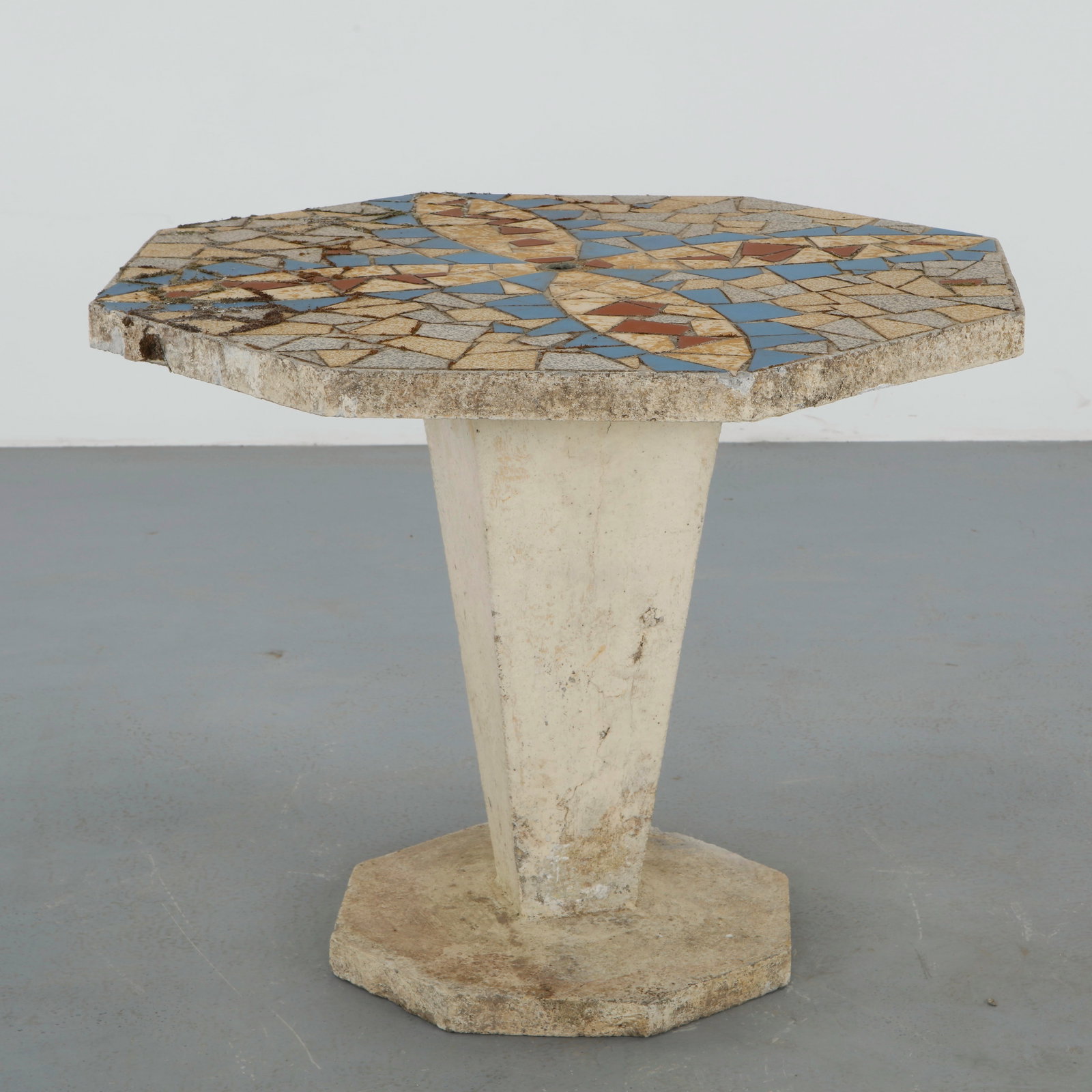 Mosaic Dining Table, 1960s: Hexagonal outdoor dining table featuring a vibrant mosaic top composed of hand cut ceramic tesserae in geometric patterns. Raised on a sculptural pedestal base, the table reflects the playful