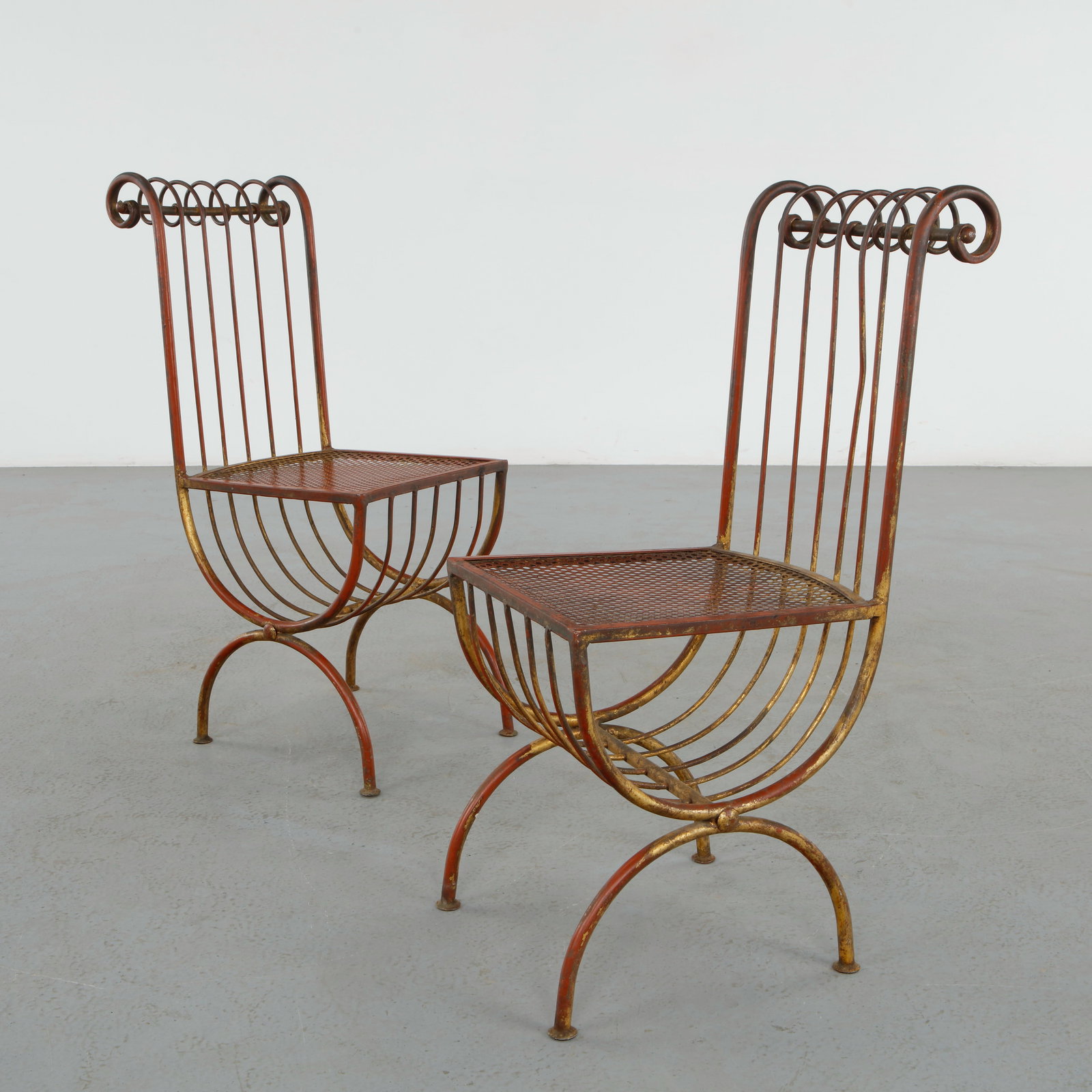 Pair of Hollywood Regency Salvadori Gilded Steel Italian Side Chairs: Sophisticated pair of Italian side chairs executed in gilt steel with elegant scrolling backs and delicately curved silhouettes. The refined openwork structure reflects the glamorous spirit of
