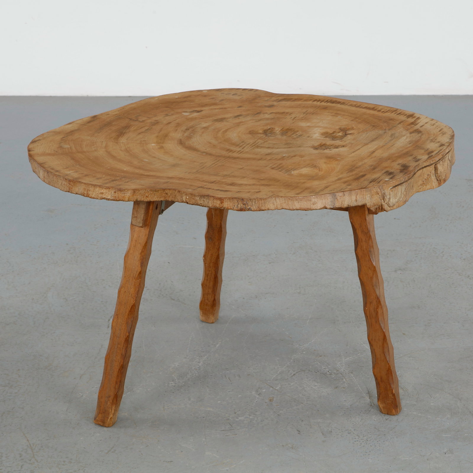 Brutalist Tripod Slab Table, 1960s: Rustic sculptural coffee table crafted from solid wood with a richly patinated live edge top and organically formed legs. The hand worked construction and primitive silhouette embody the raw materiali