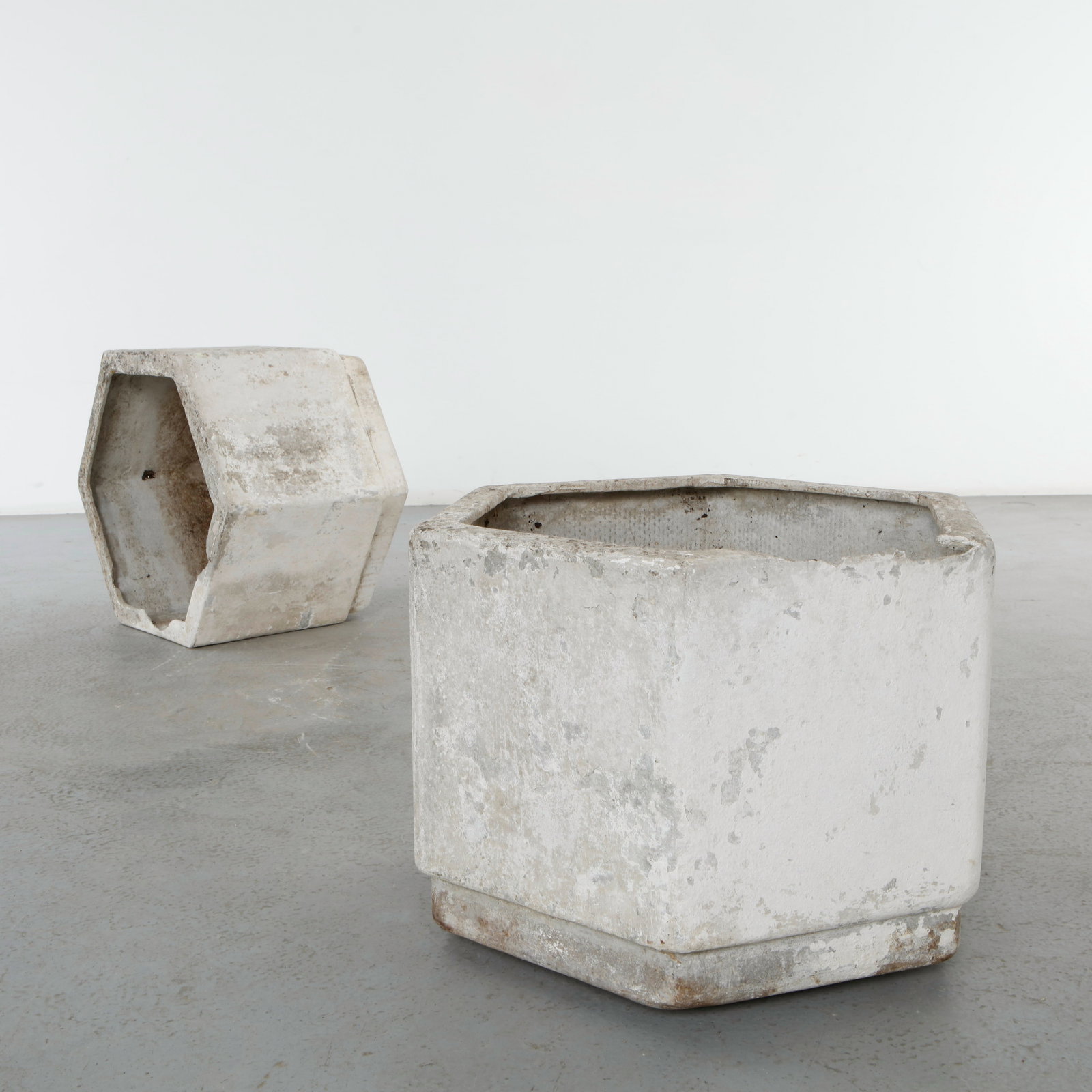 Willy Guhl, Pair of Hexagonal Concrete Planters, 1960s: Pair of hexagonal molded concrete planters raised on metal stands. Displaying expressive aging with traces of lichen and mineral deposits. Highly sought-after examples of Swiss modernist outdoor desig