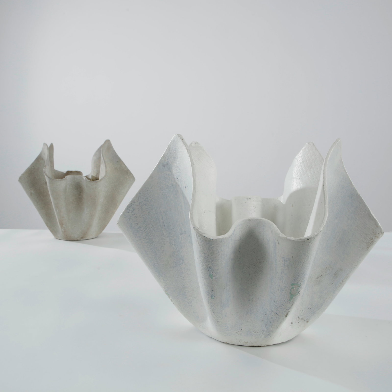 Willy Guhl, Pair of Small Tulip Planters, 1960s: A rare pair of small Tulip planters by Willy Guhl, crafted in fiber cement with elegantly folded contours inspired by blooming petals. Their sculptural profiles and soft weathered finish exemplify the