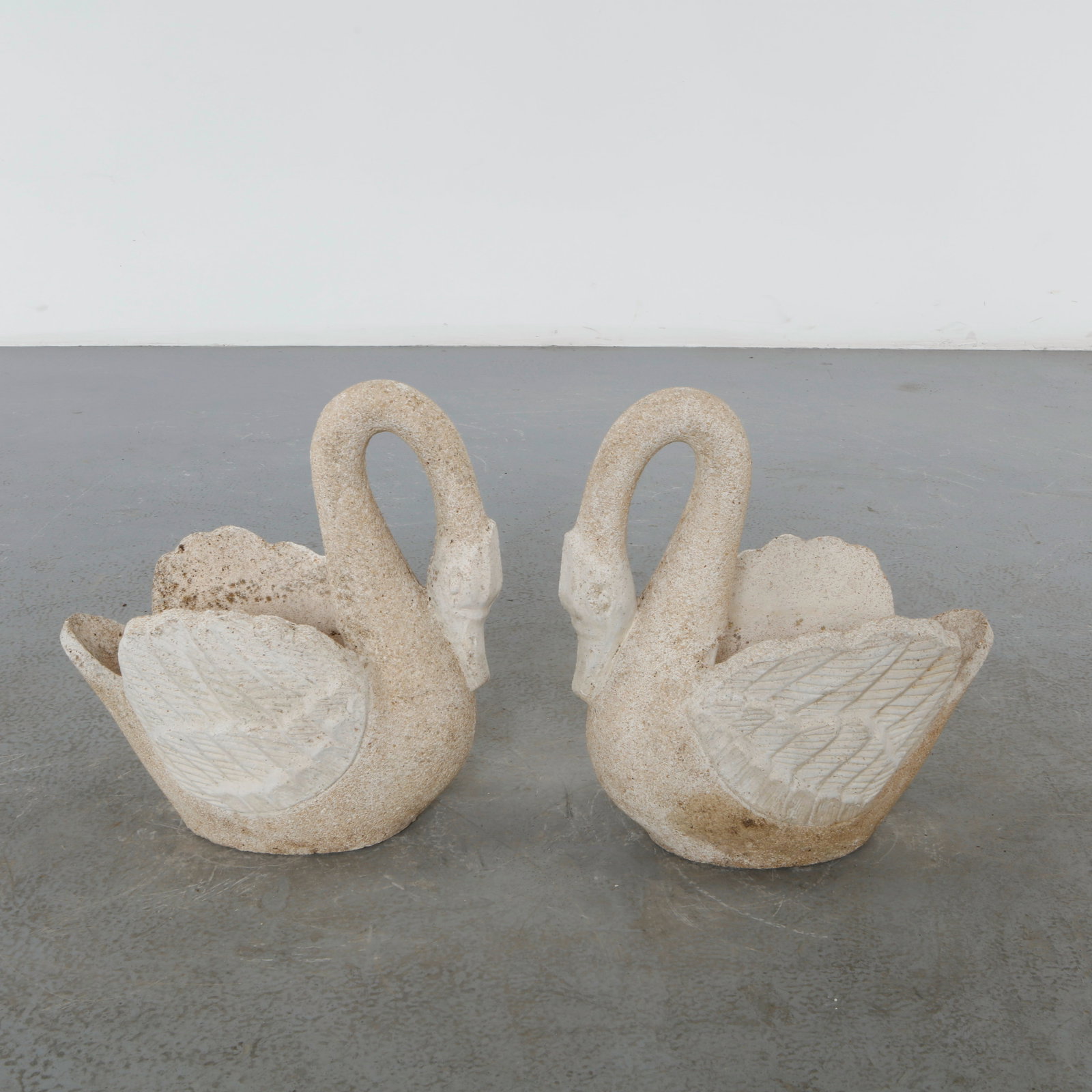 Pair of Concrete Swan Planters, 1960s: A charming pair of cast concrete swan planters, sculpted with gracefully curved necks and finely detailed wings. Their weathered patina and whimsical form make them a timeless addition to both garden