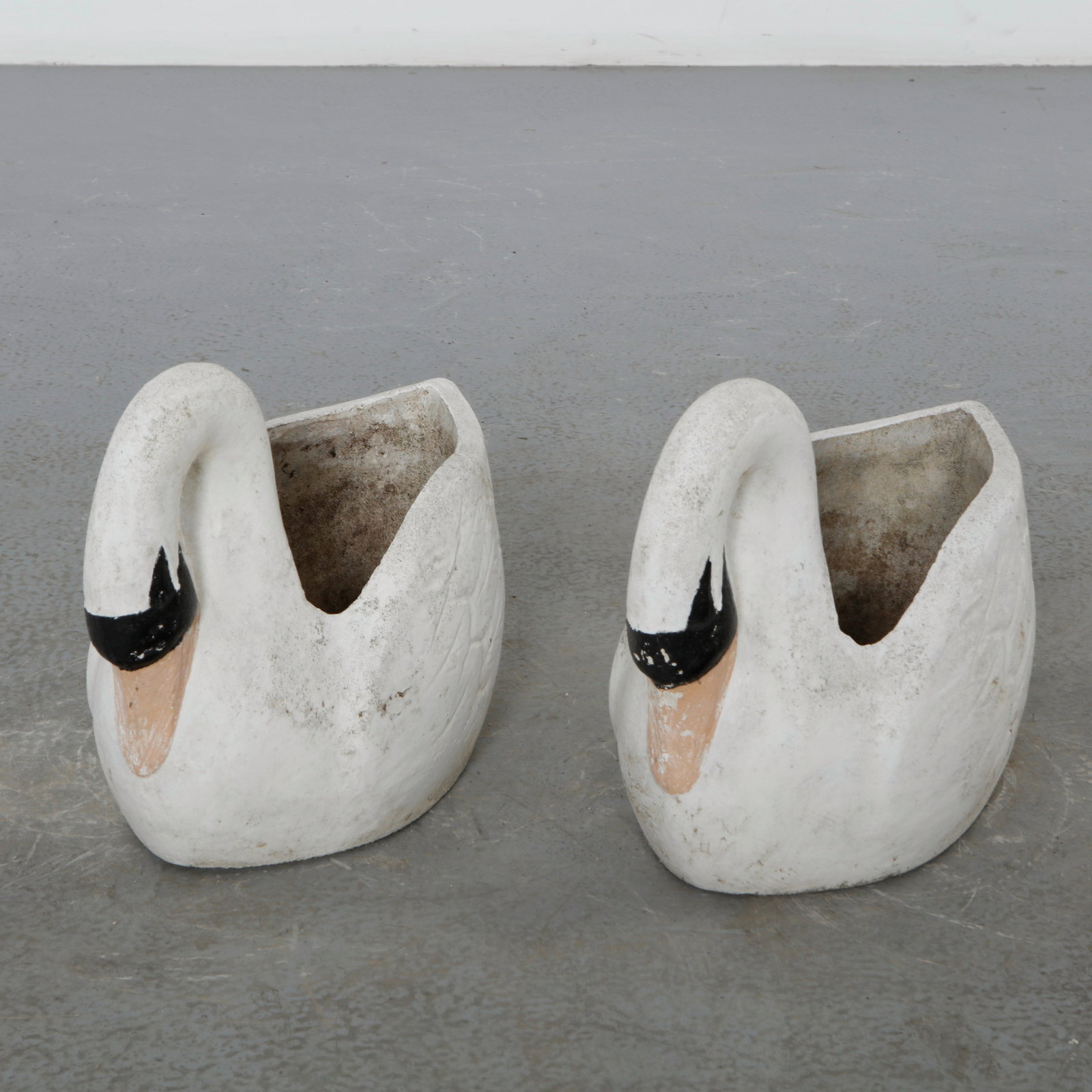 Pair of Concrete Swan Planters, 1960s: Cast in concrete and painted in white with subtle detailing, this pair of swan-shaped planters embodies playful romanticism. Their sculptural forms add both grace and nostalgia to outdoor