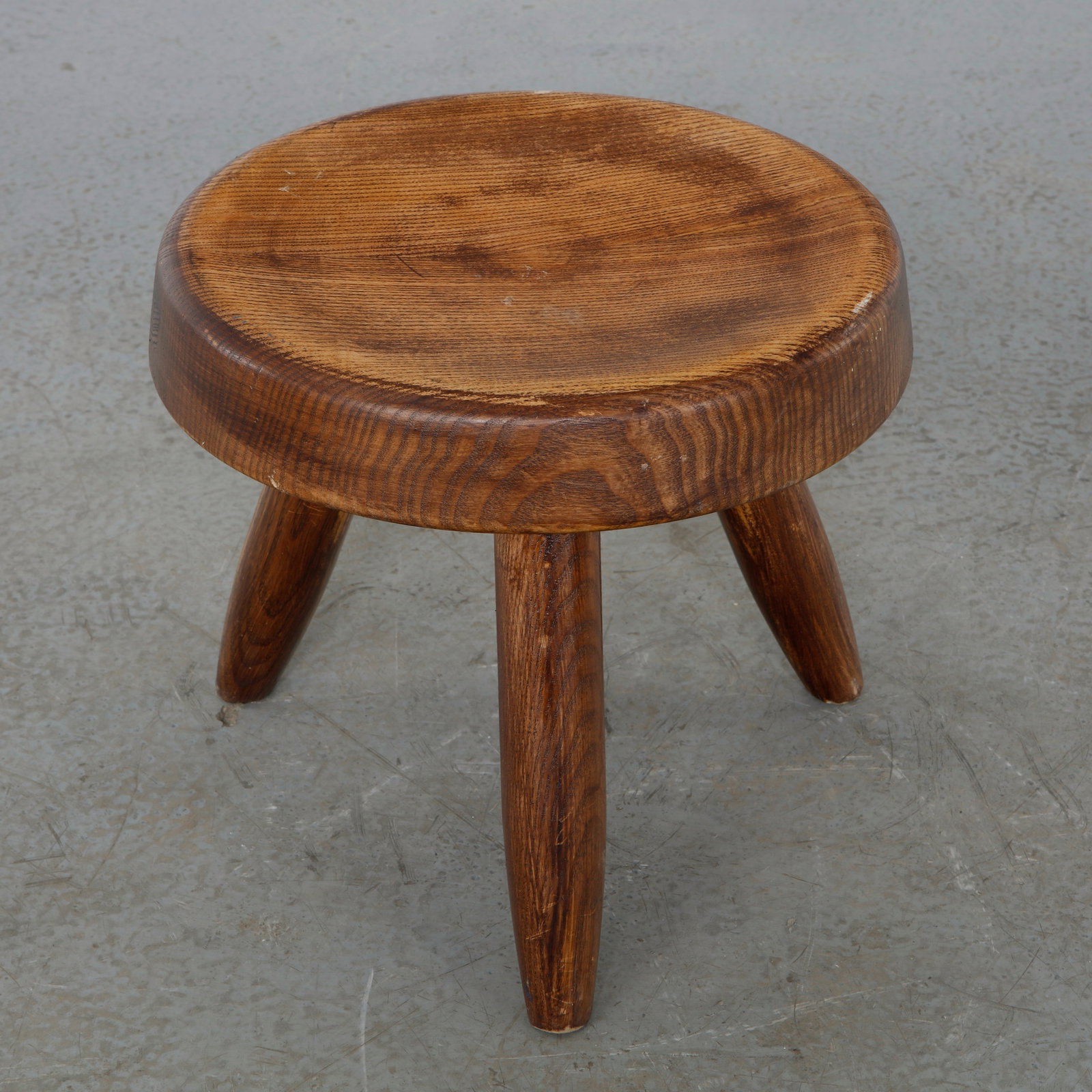 Berger Stool attributed to Charlotte Perriand, 1960s: Solid pine Berger stool attributed to Charlotte Perriand, featuring a thick circular seat raised on three splayed cylindrical legs. Crafted with exposed through-tenon joinery, this rustic yet refined 