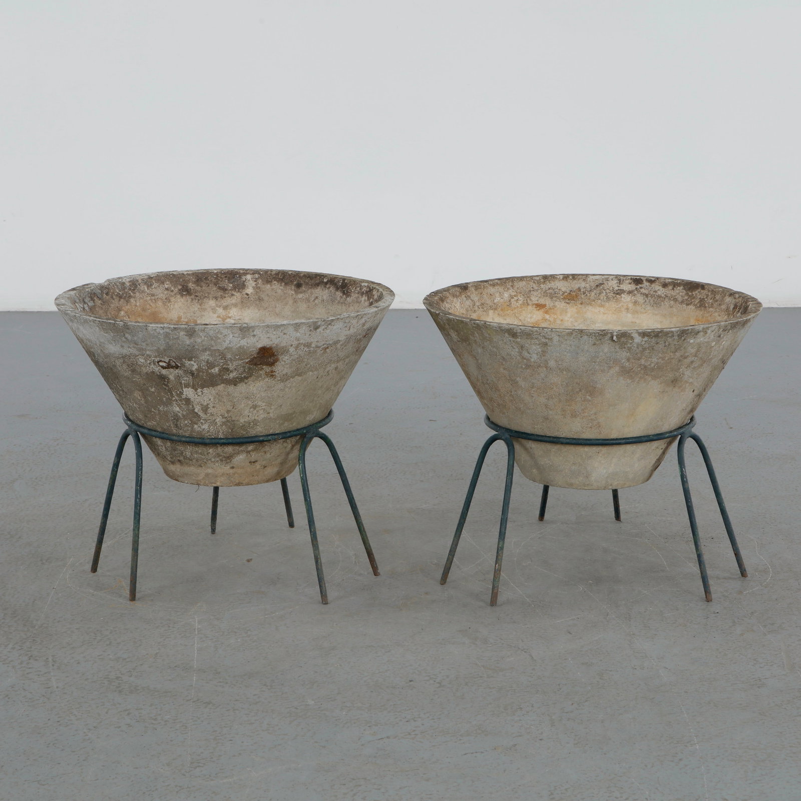 Willy Guhl, Pair of Conical Planters on Stands, 1960s: Iconic Willy Guhl silhouettes in compact form, these conical planters rest atop minimalistic metal stands, weathered yet timeless. Height: 19 in. Diameter: 22 in.